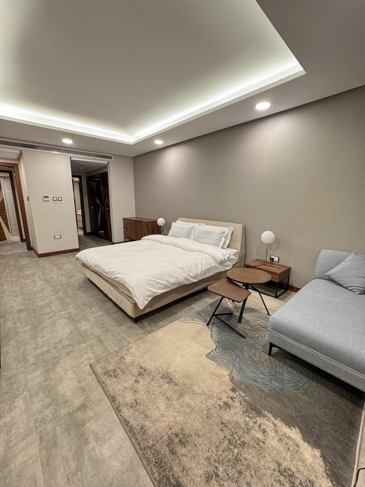 a large bedroom with a bed and a couch at Skyline Suite in Hidd Heights in Manama +38 photos