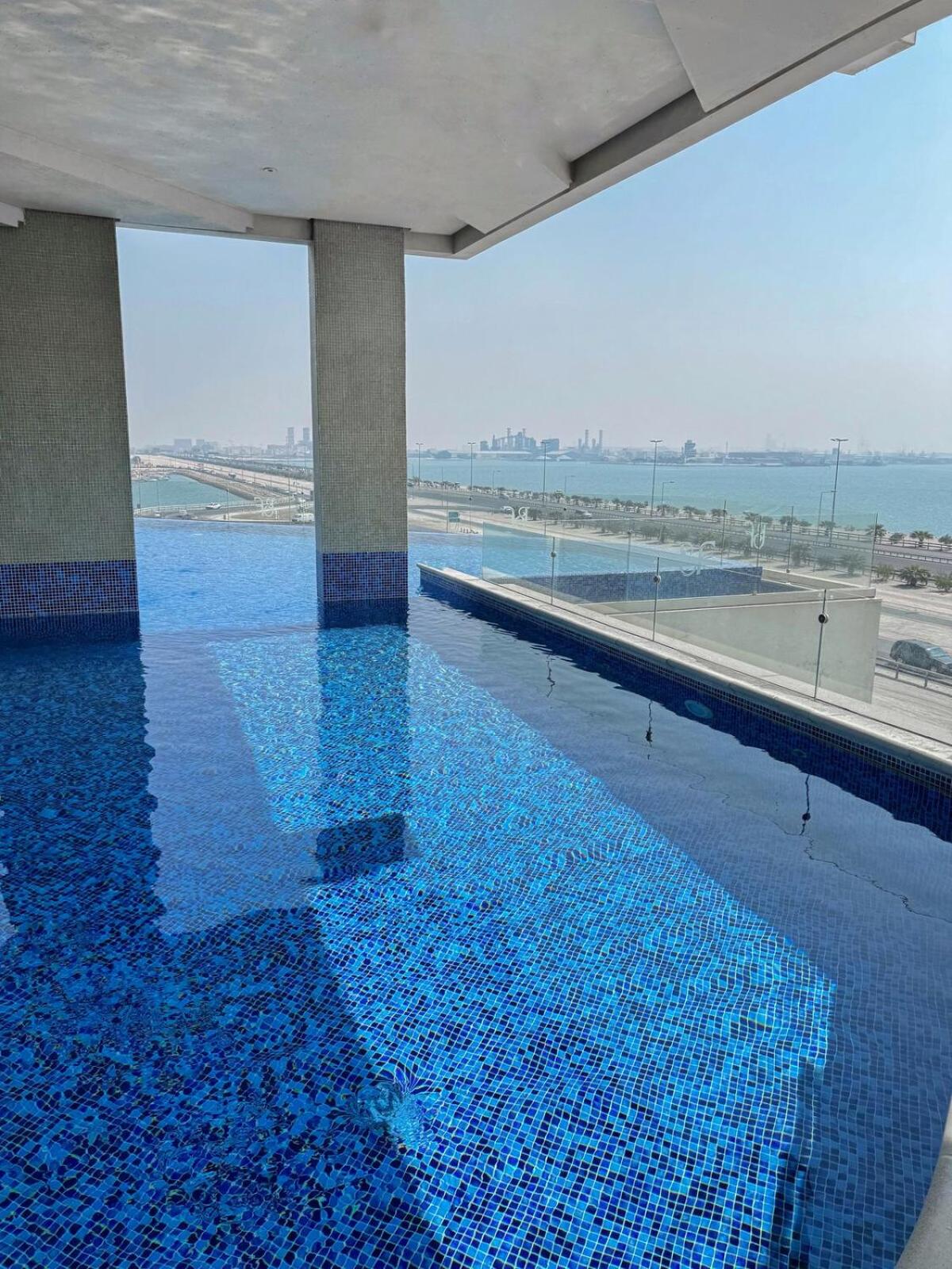 a swimming pool with a view of the ocean at Skyline Suite in Hidd Heights in Manama