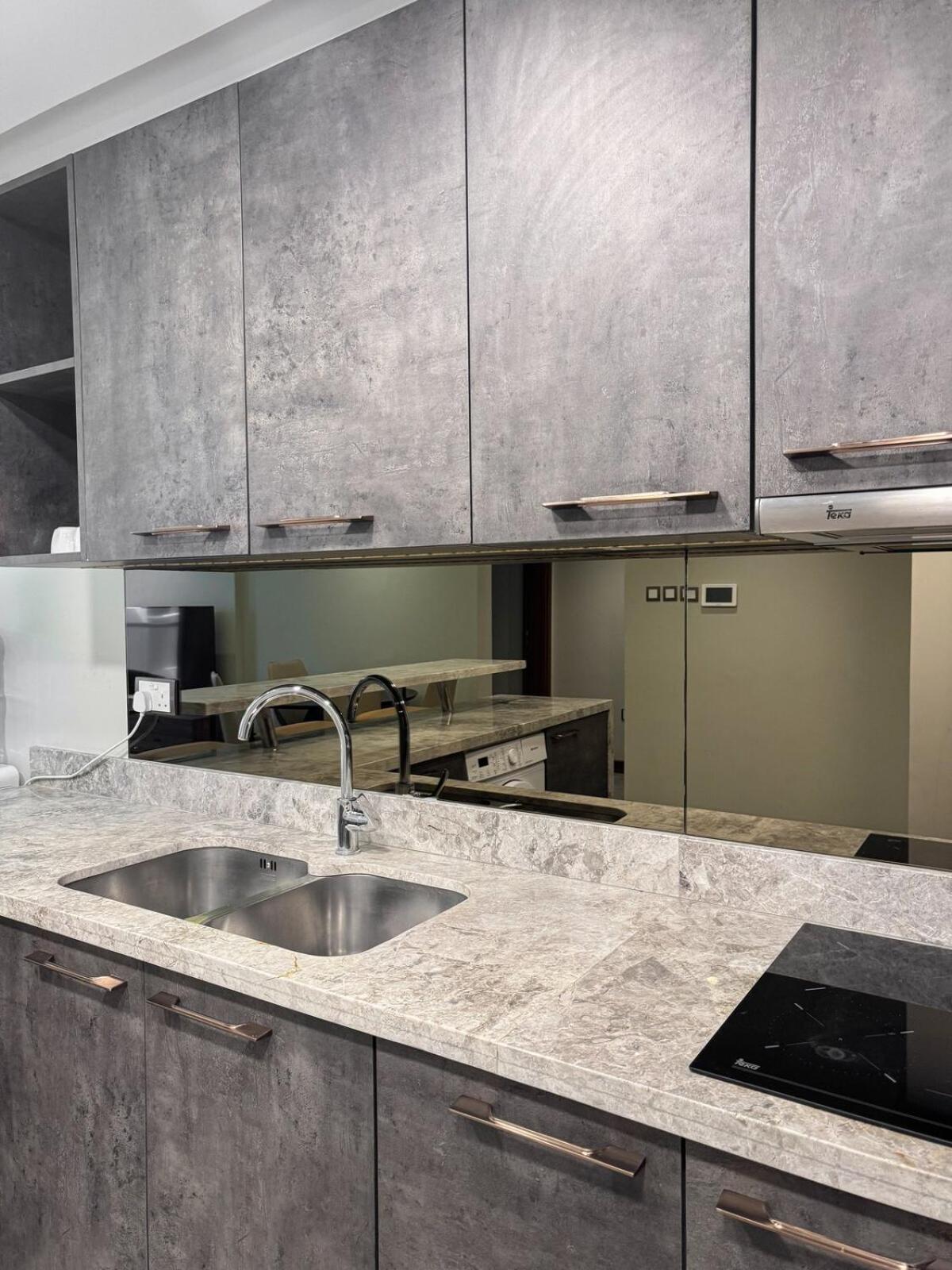 a kitchen with stainless steel cabinets and a sink at Skyline Suite in Hidd Heights in Manama