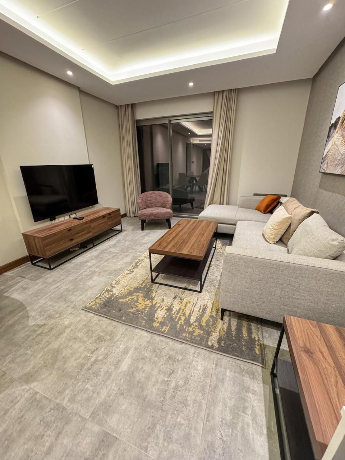 a living room with a couch and a flat screen tv at Skyline Suite in Hidd Heights in Manama
