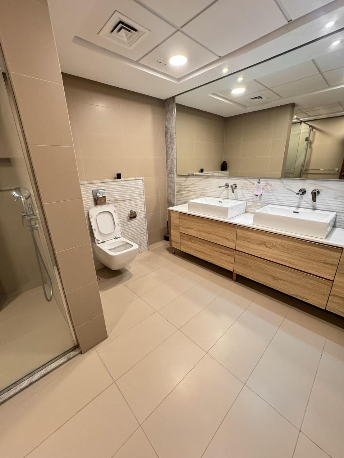 a bathroom with a toilet and a tub and a sink at Skyline Suite in Hidd Heights in Manama