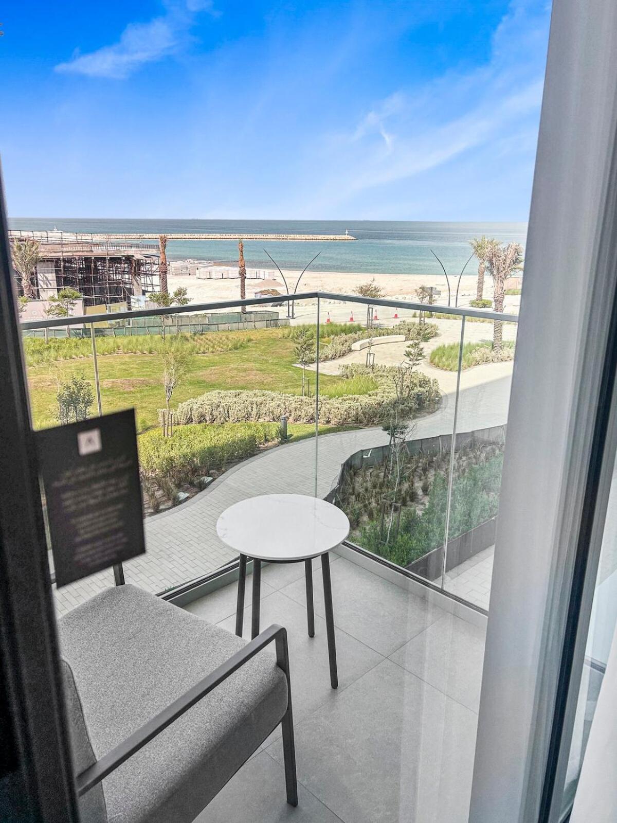 a balcony with a table and a view of the beach at Address Residence Marrasi Vista Apartment with Sea View in Amwaj Island