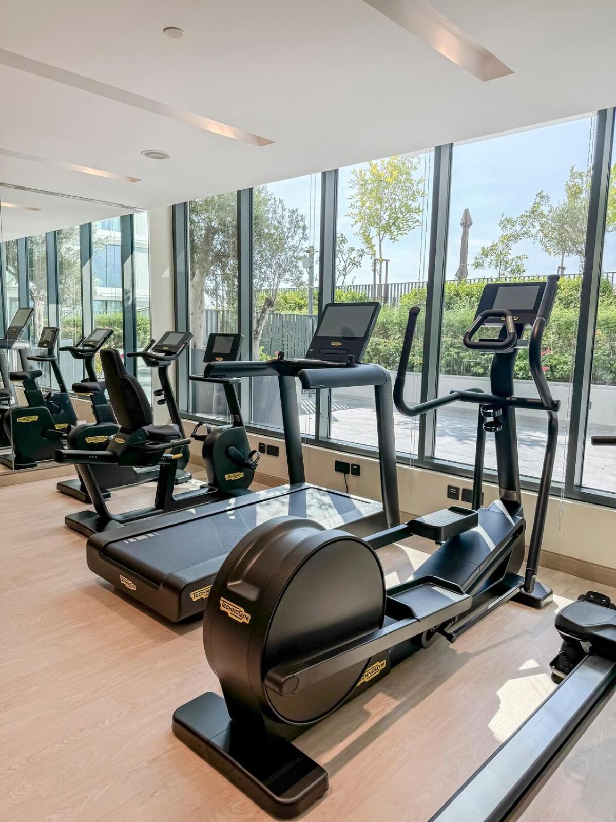 a gym with rows of treadmills and elliptical machines at Address Residence Marrasi Vista Apartment with Sea View in Amwaj Island