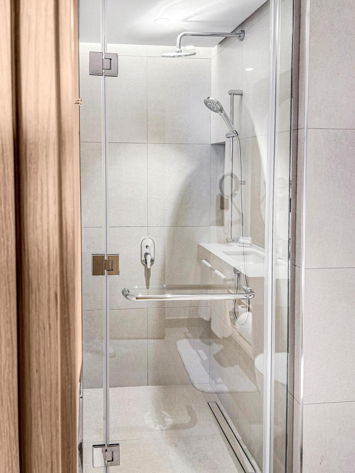 a shower with a glass door in a bathroom at Address Residence Marrasi Vista Apartment with Sea View in Amwaj Island