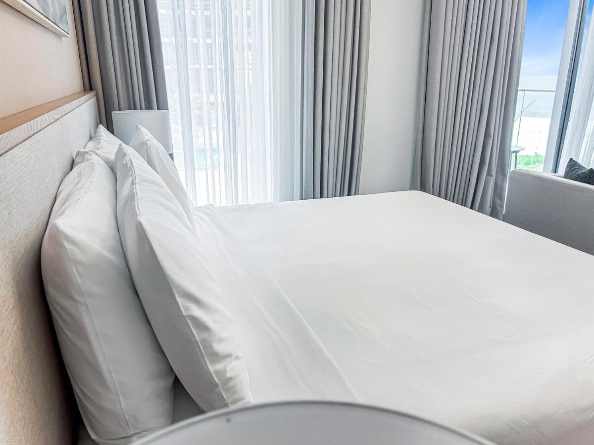 a bed with white pillows in a hotel room at Fancy Studio in Address Residence Marassi Vista in Amwaj Island
