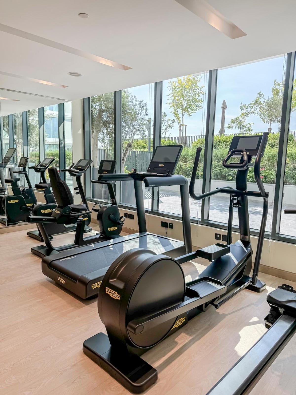 a gym with a row of treadmills and elliptical machines at Luxurious Studio in Marassi Vista with Beach Access in Amwaj Island