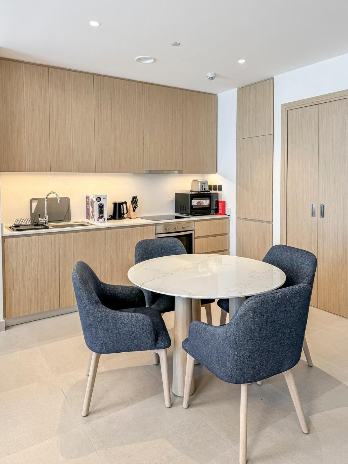 a kitchen with a table and two chairs at Luxurious Studio in Marassi Vista with Beach Access in Amwaj Island