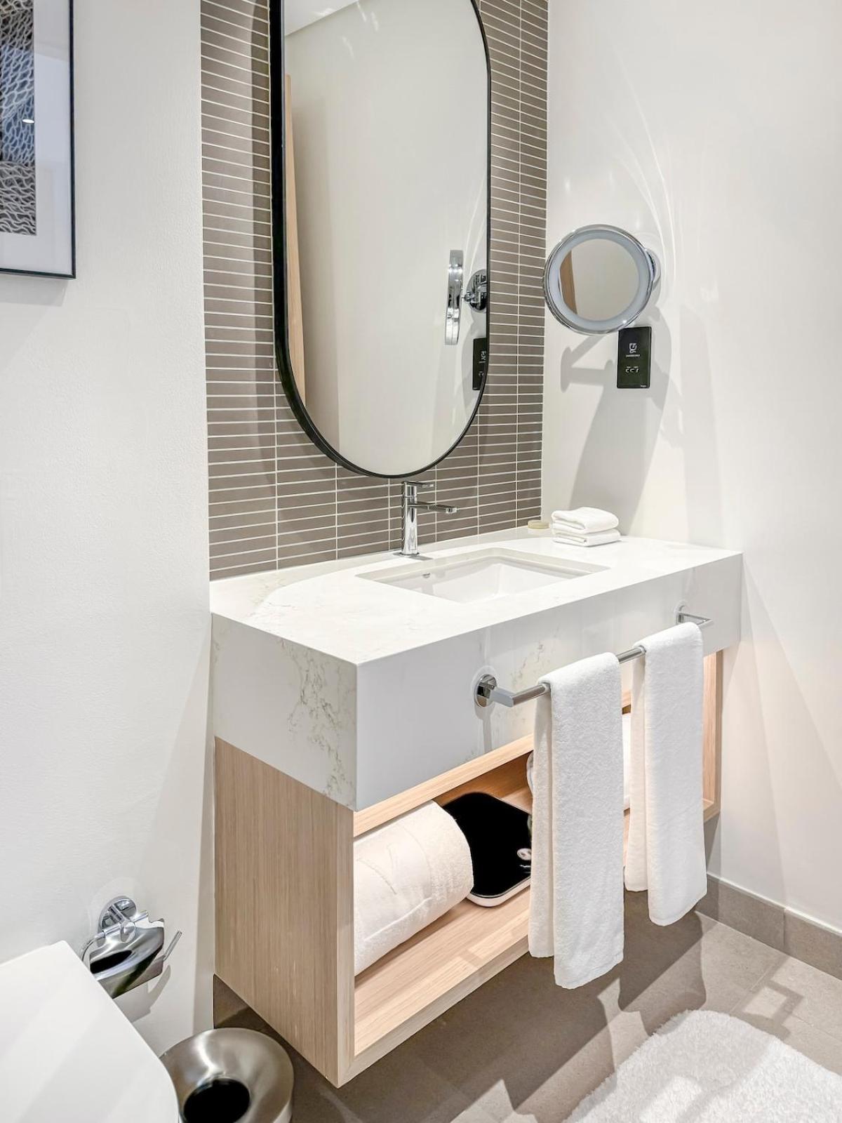 a bathroom with a sink with a mirror and towels at Luxurious Studio in Marassi Vista with Beach Access in Amwaj Island