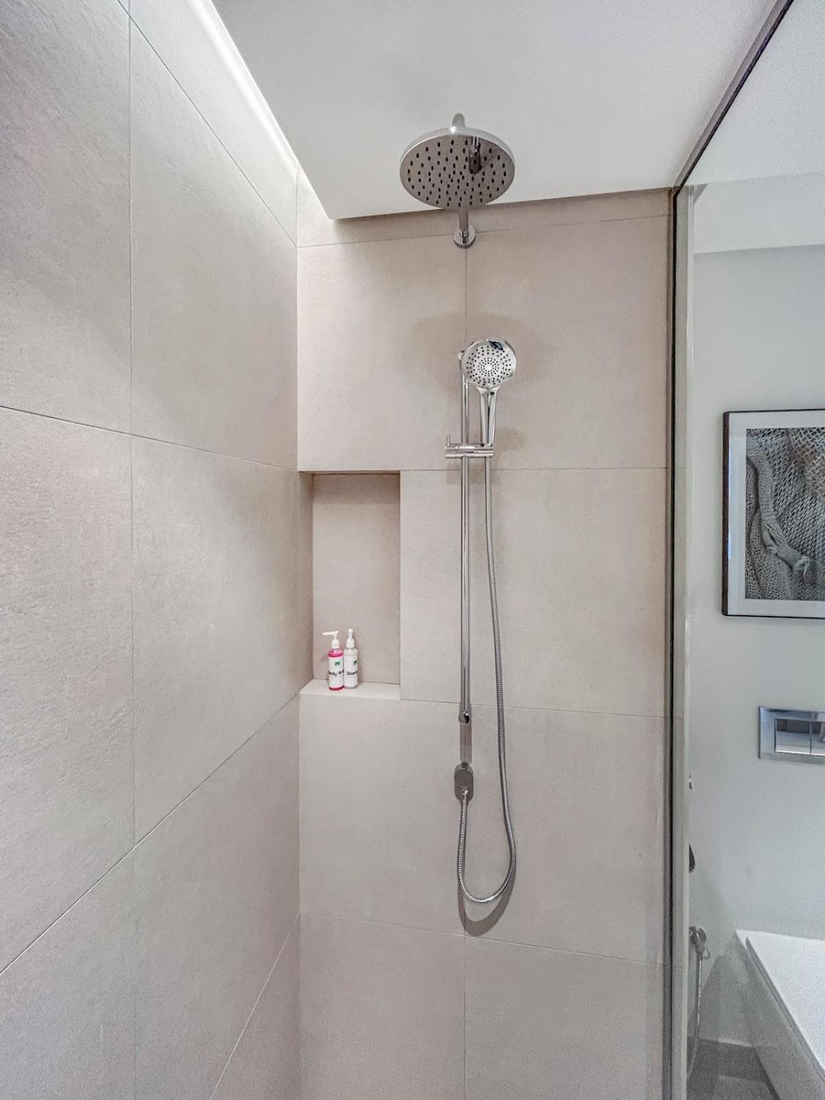 a shower with a shower head in a bathroom at Marassi Vista 1BR Gem with Beach Access near Mall in Amwaj Island
