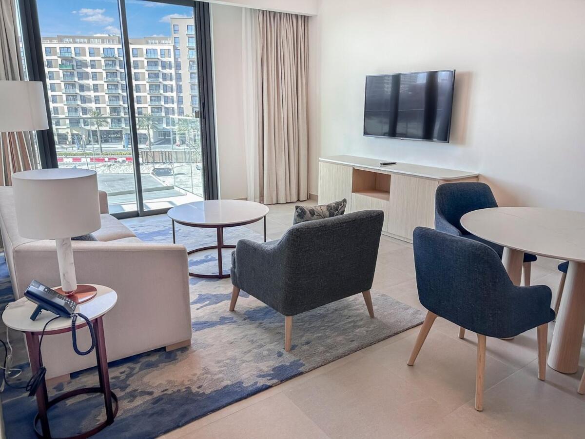 a hotel room with chairs and tables and a large window at Marassi Vista 1BR Gem with Beach Access near Mall in Amwaj Island