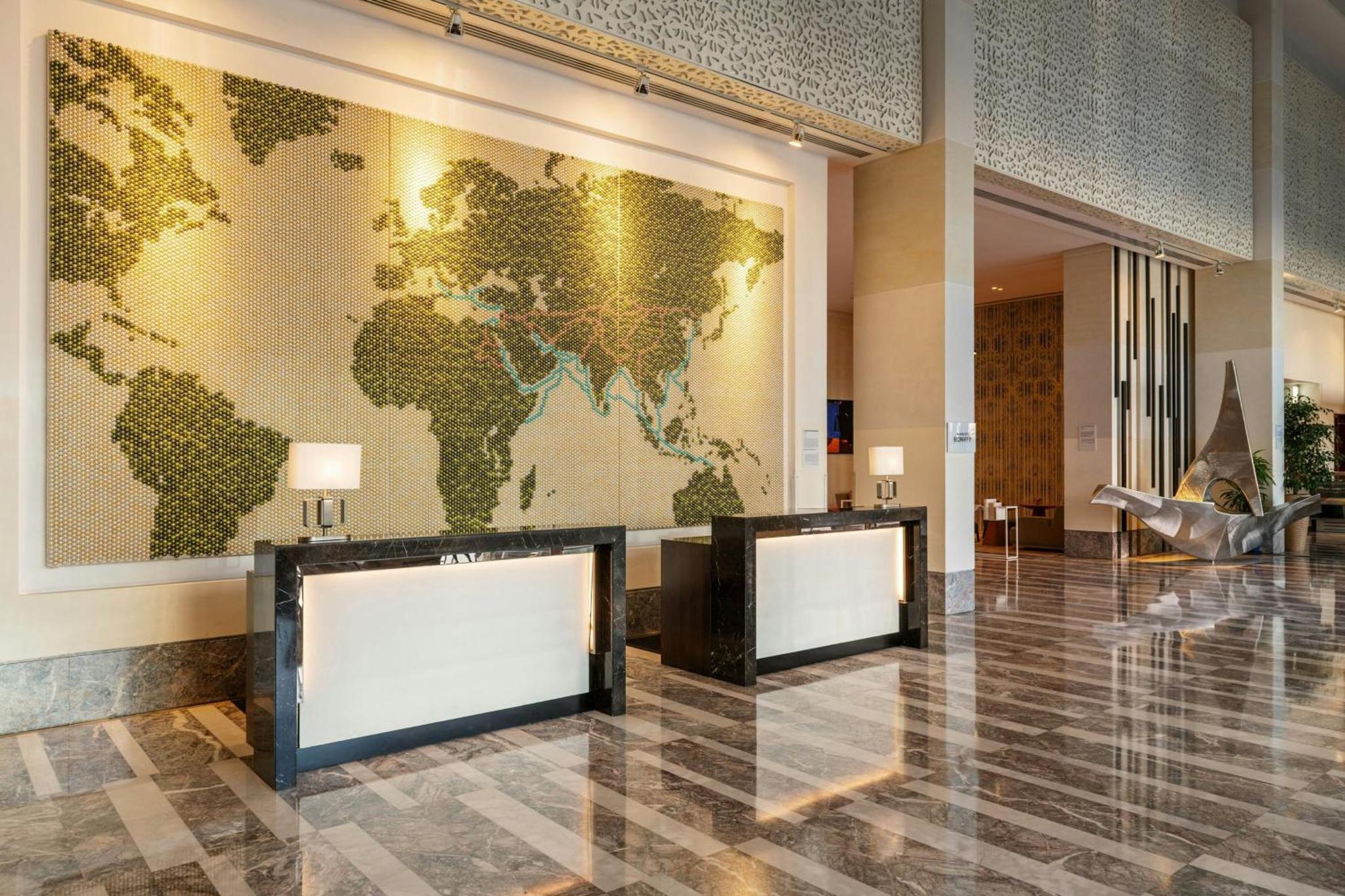 a lobby with a map of the world on the wall at Le Meridien City Centre Bahrain in Manama +98 photos