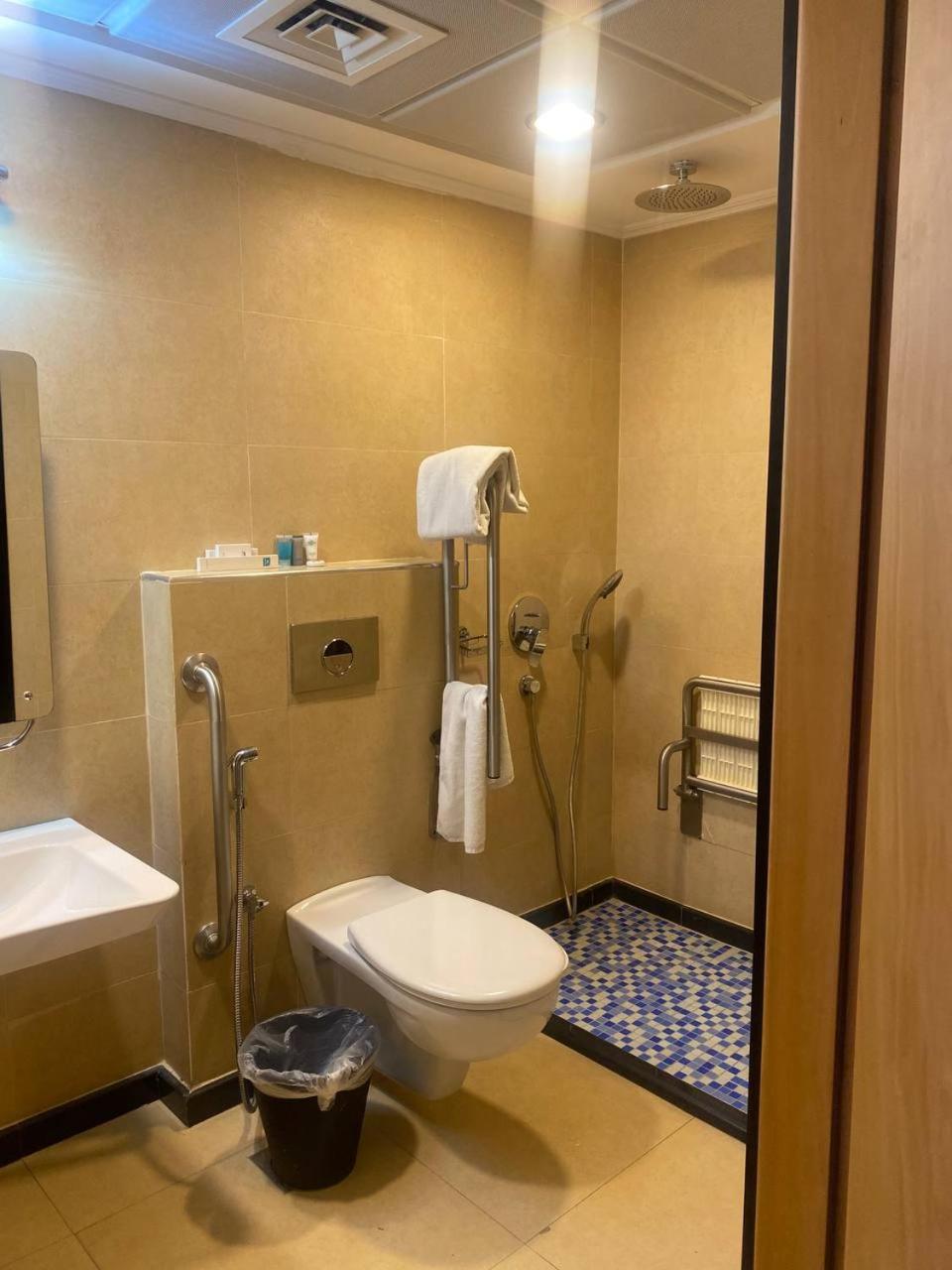 a bathroom with a toilet and a sink at Nooh Apartment in Al Ḩadd