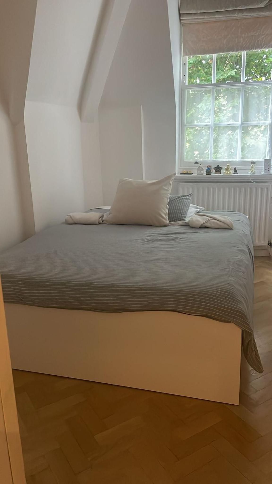a large bed in a bedroom with a window at Top view Notting Hill Kensington in London