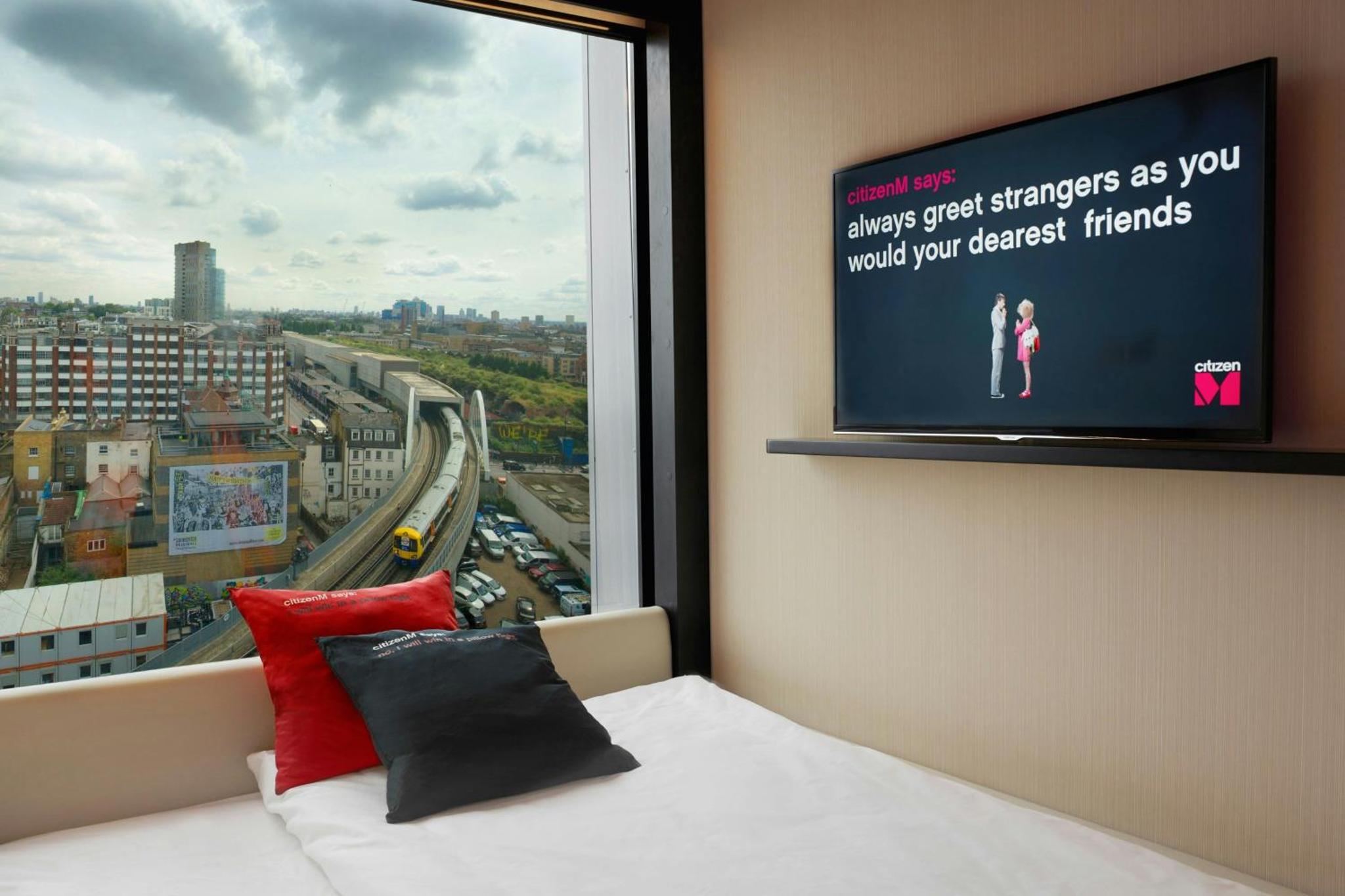 a bedroom with a large window with a tv at citizenM London Shoreditch in London