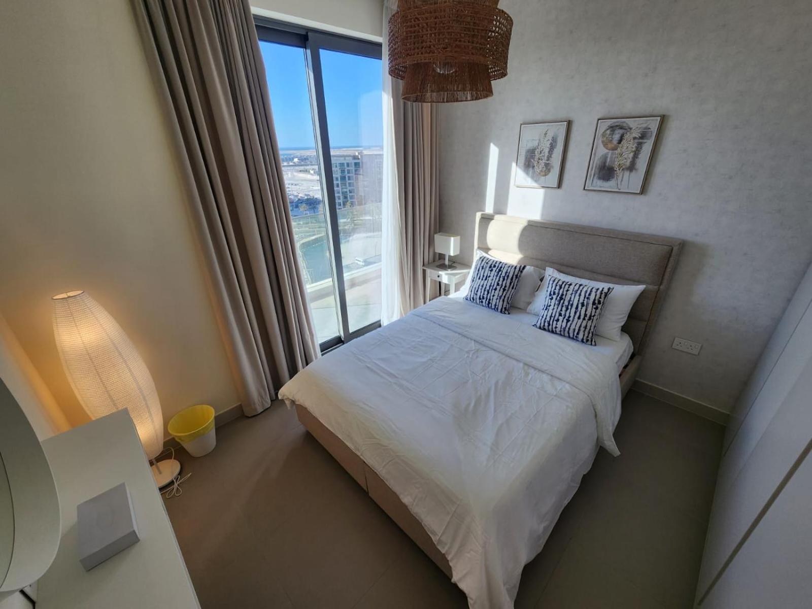 a bedroom with a bed and a large window at Elite 2BR Abode Distinctive Living at The Shores in Manama +41 photos
