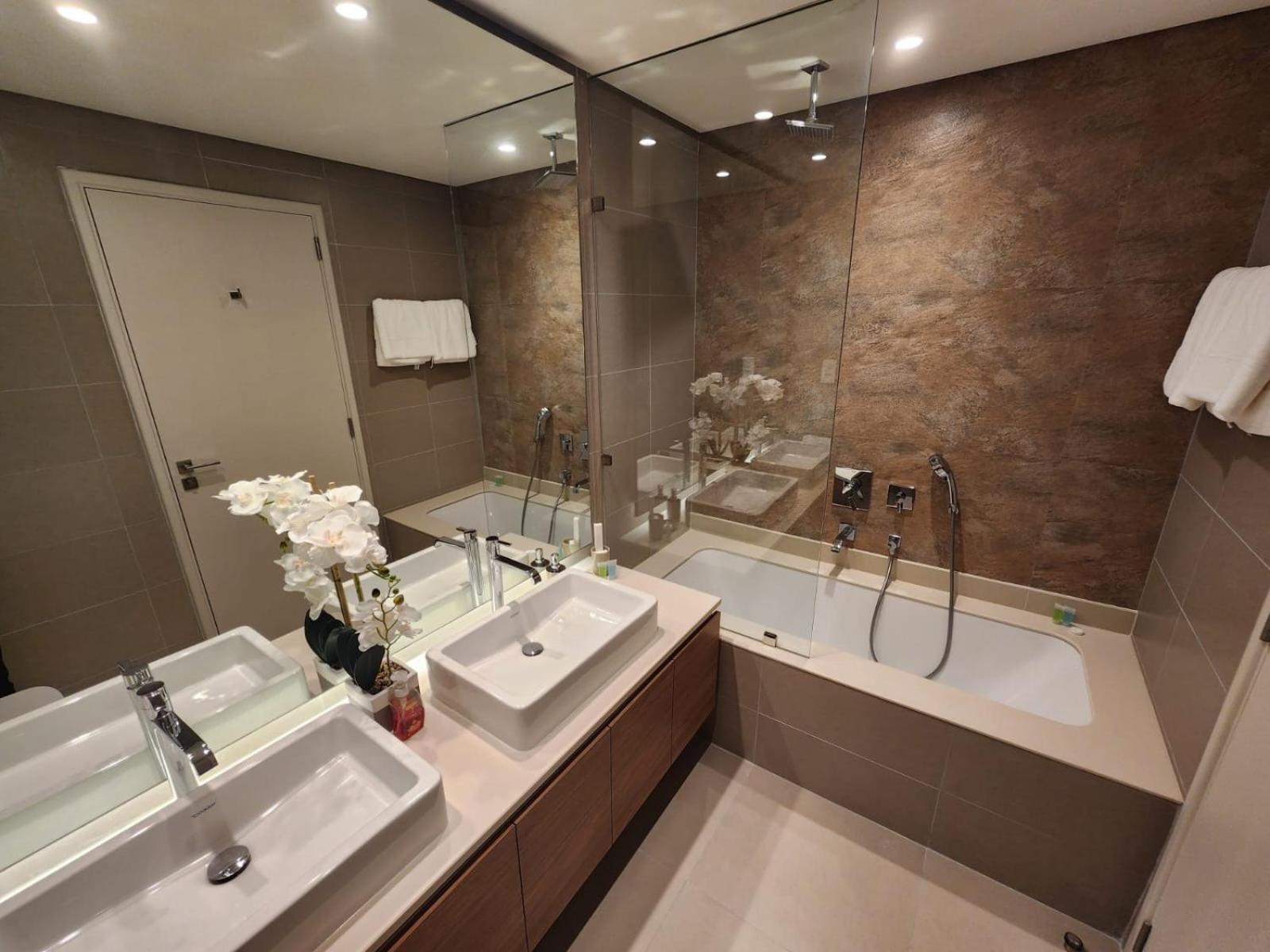 a bathroom with two sinks and a bath tub at Elite 2BR Abode Distinctive Living at The Shores in Manama
