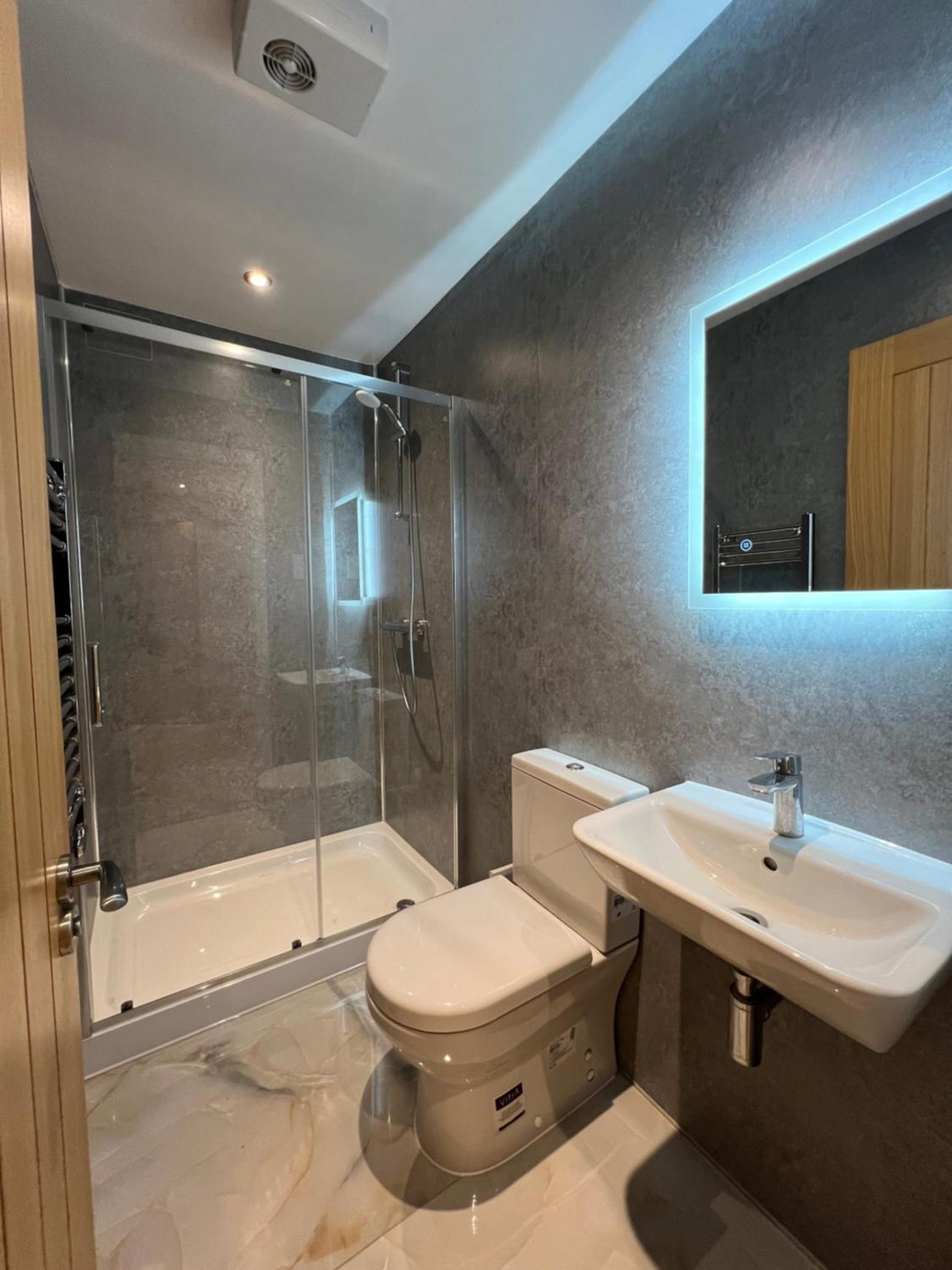 a bathroom with a toilet and a sink and a shower at HideAway London in London