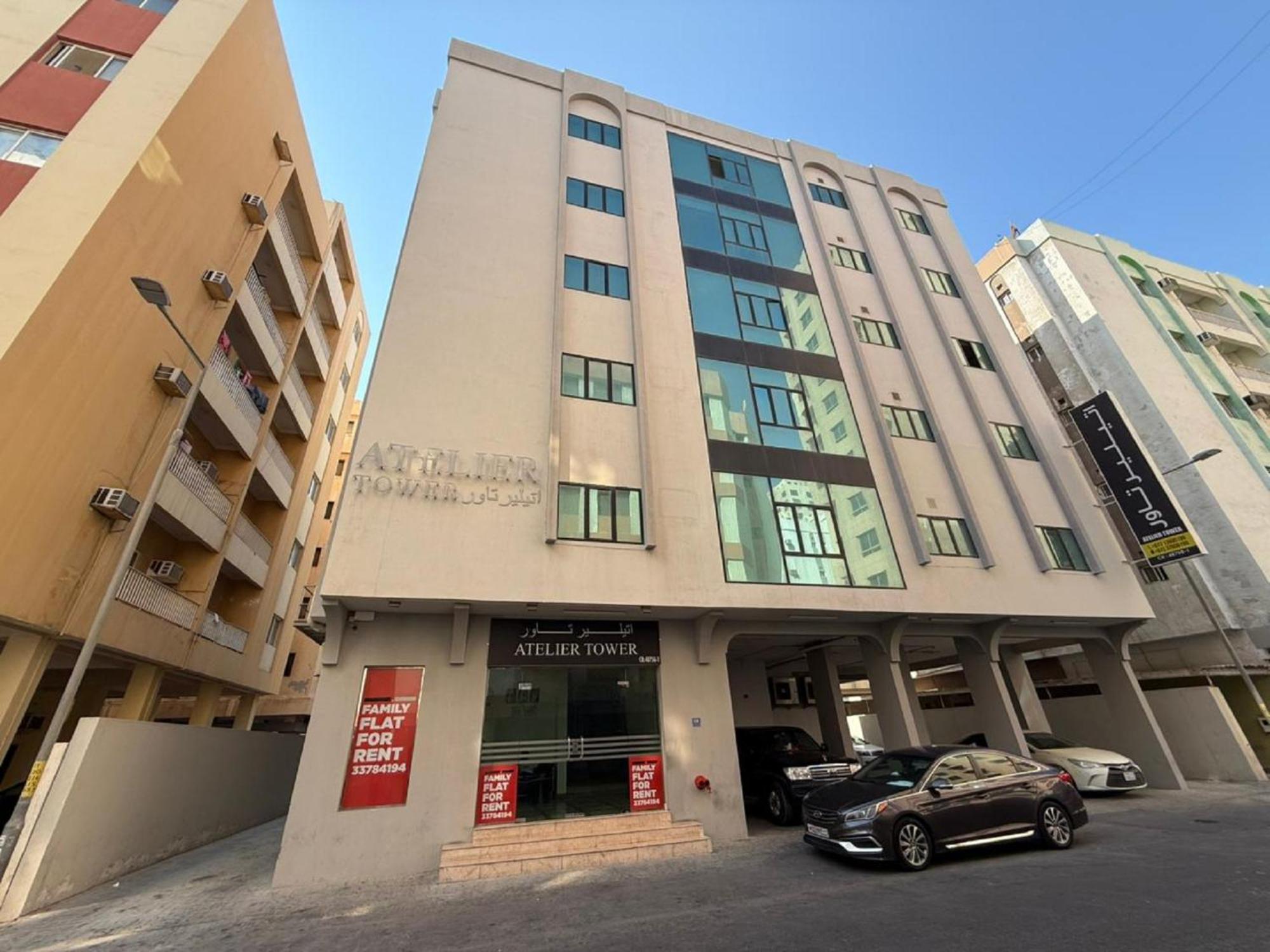 a building with a car parked in front of it at Atelier Tower Hoora - Family Apartment in Manama