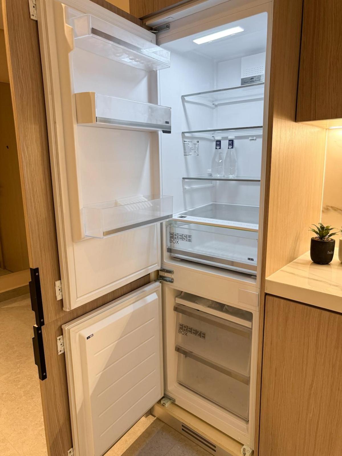 an empty refrigerator with its door open in a kitchen at 1BR with Executive Sea View in Financial Harbour in Manama