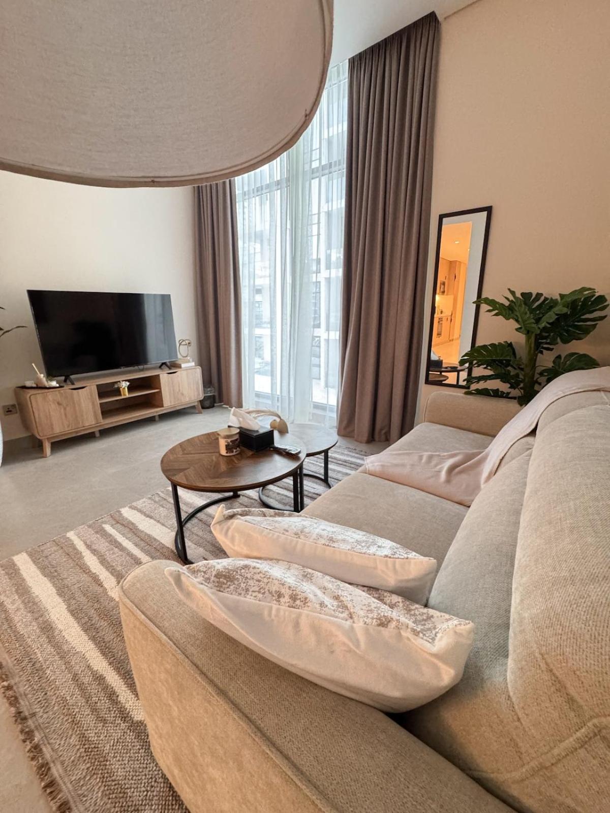 a living room with a couch and a tv at 1BR with Executive Sea View in Financial Harbour in Manama