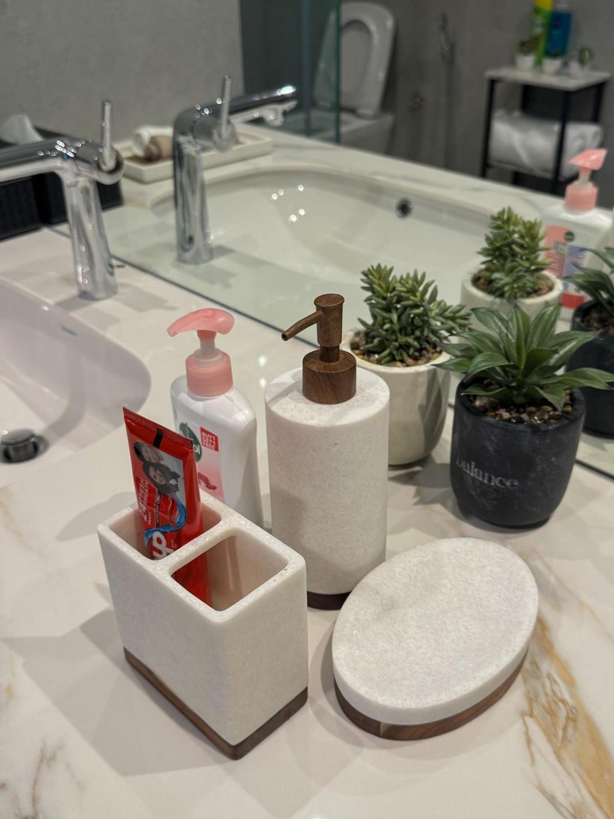 a bathroom sink with two soap dispensers and plants at 1BR with Executive Sea View in Financial Harbour in Manama