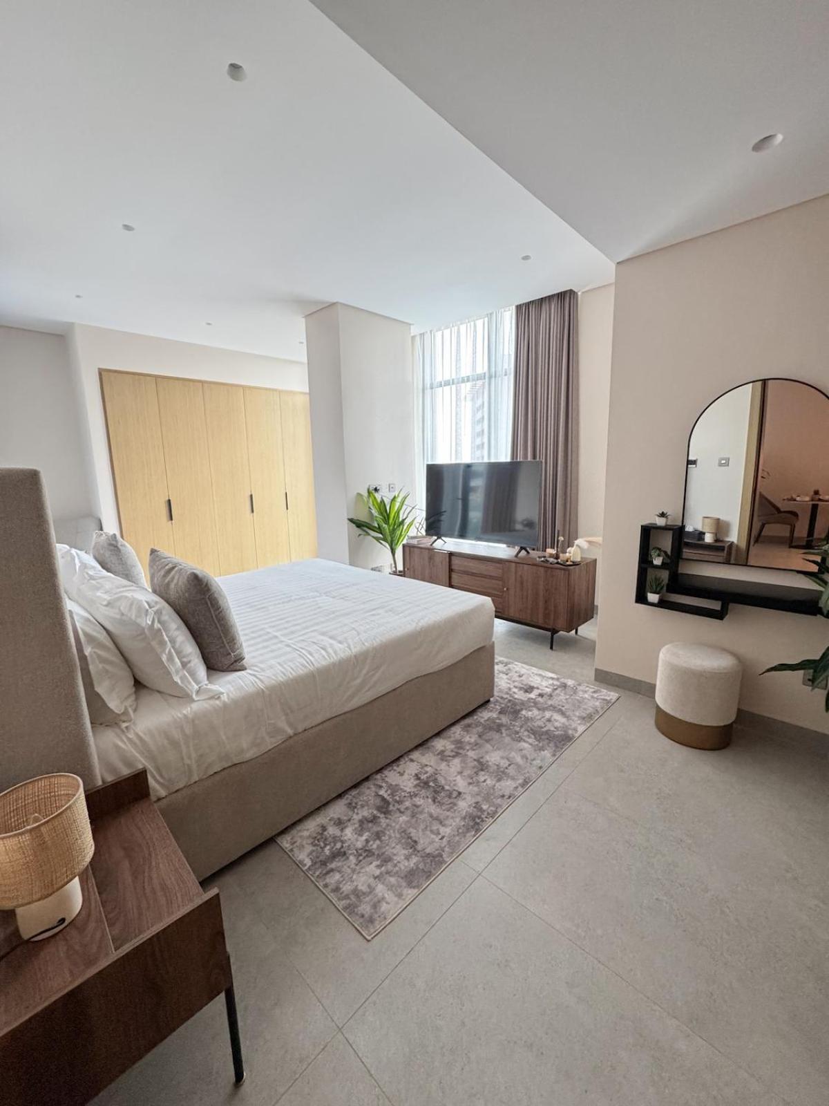 a bedroom with a large bed and a television at 1BR with Executive Sea View in Financial Harbour in Manama