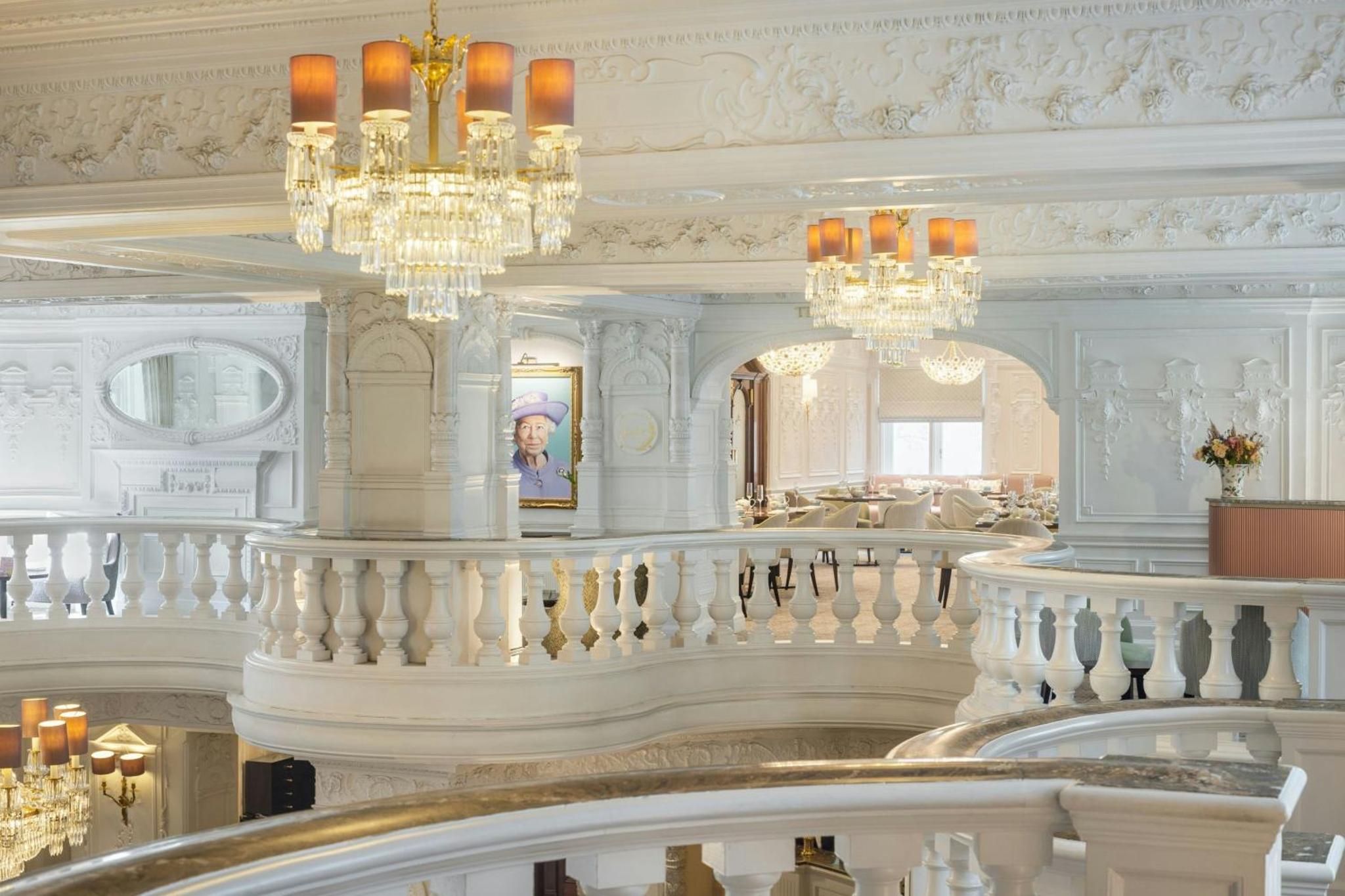 a staircase with chandeliers in a building with a staircase at St. Ermin's Hotel, Autograph Collection in London