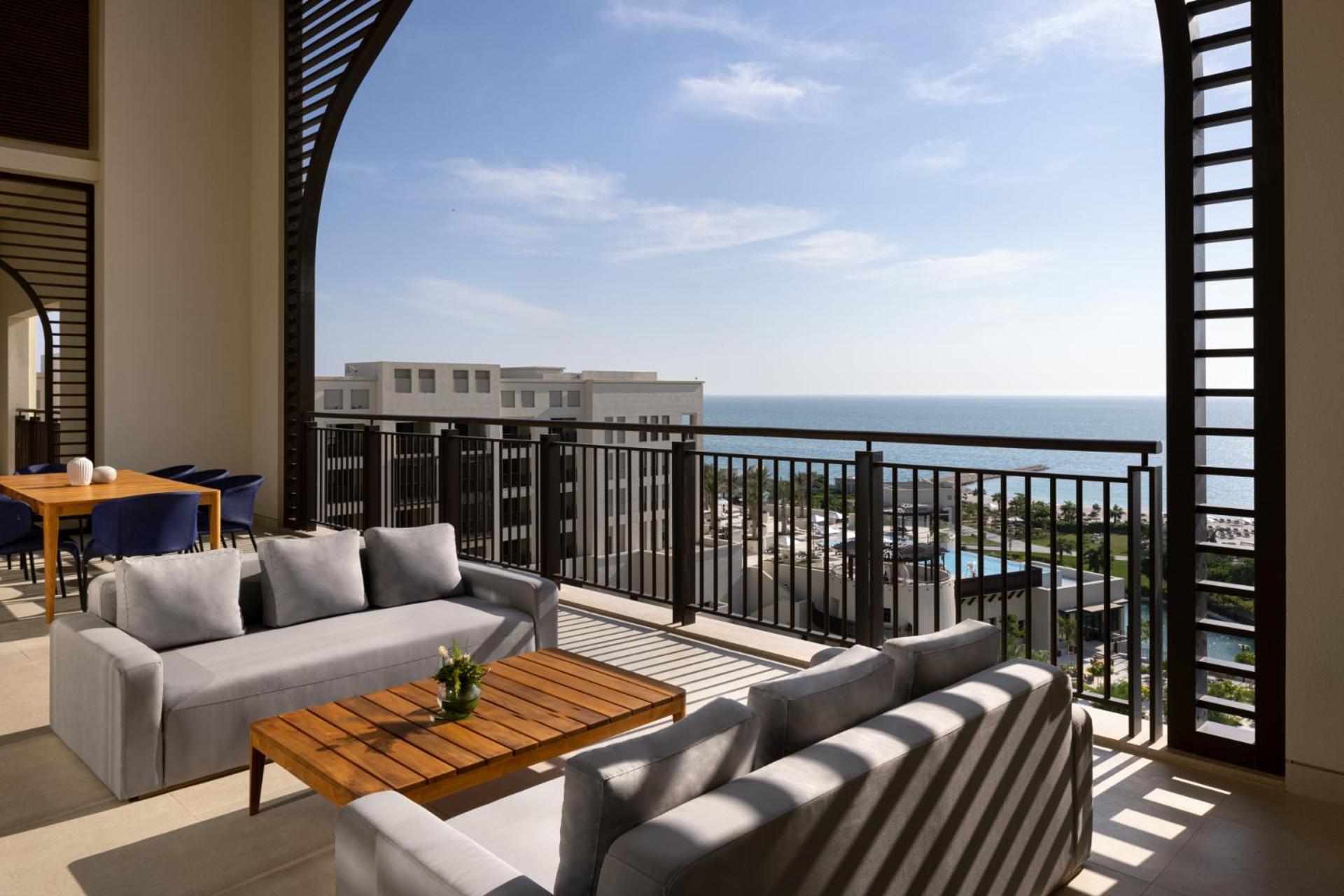 a balcony with couches and a view of the ocean at Jumeirah Gulf of Bahrain in Manama +118 photos