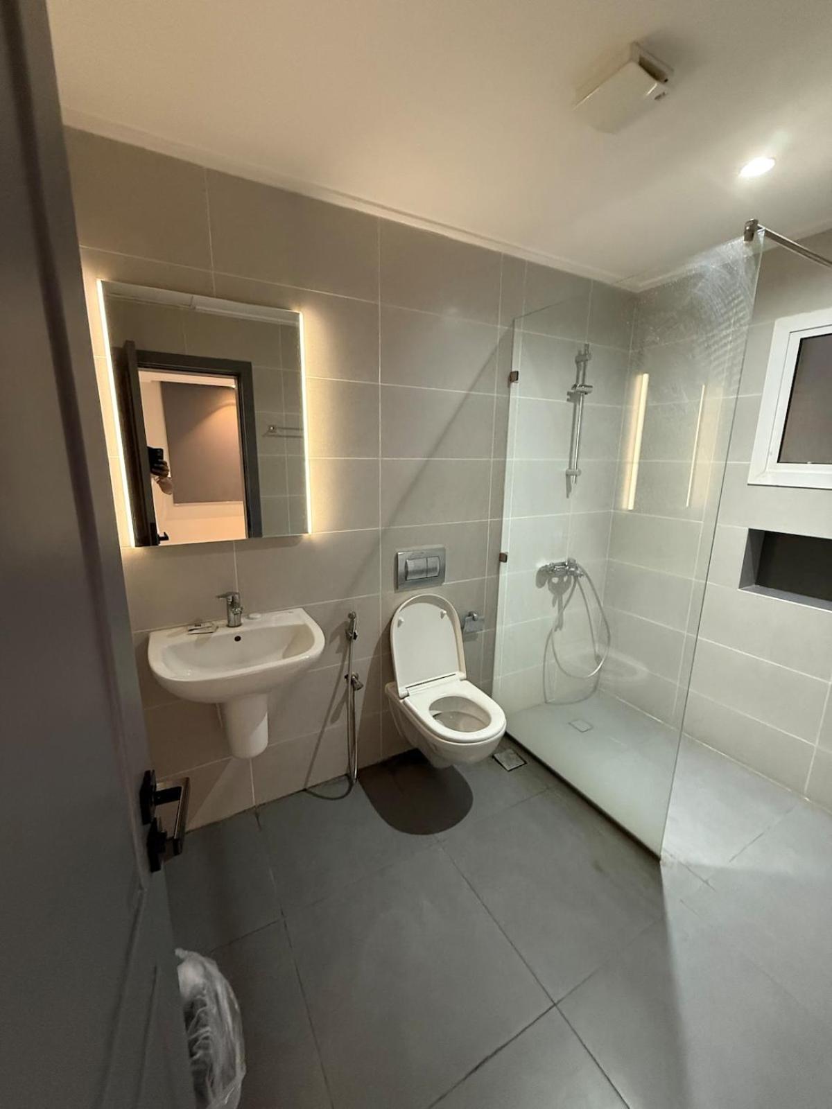 a bathroom with a toilet and a sink at Atelier Tower Hoora - Family Apartment in Manama +28 photos