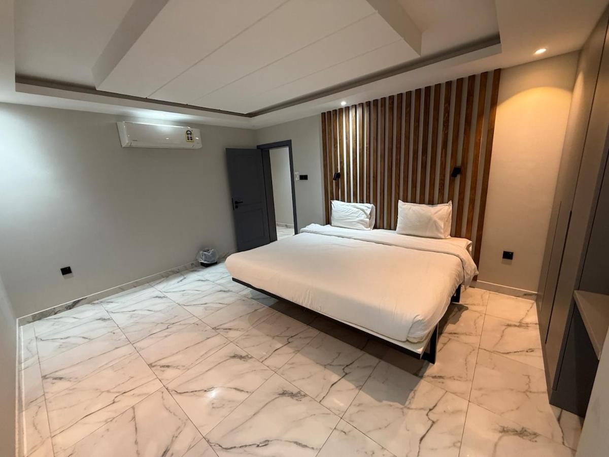 a bed in a room with a marble floor at Atelier Tower Hoora - Family Apartment in Manama