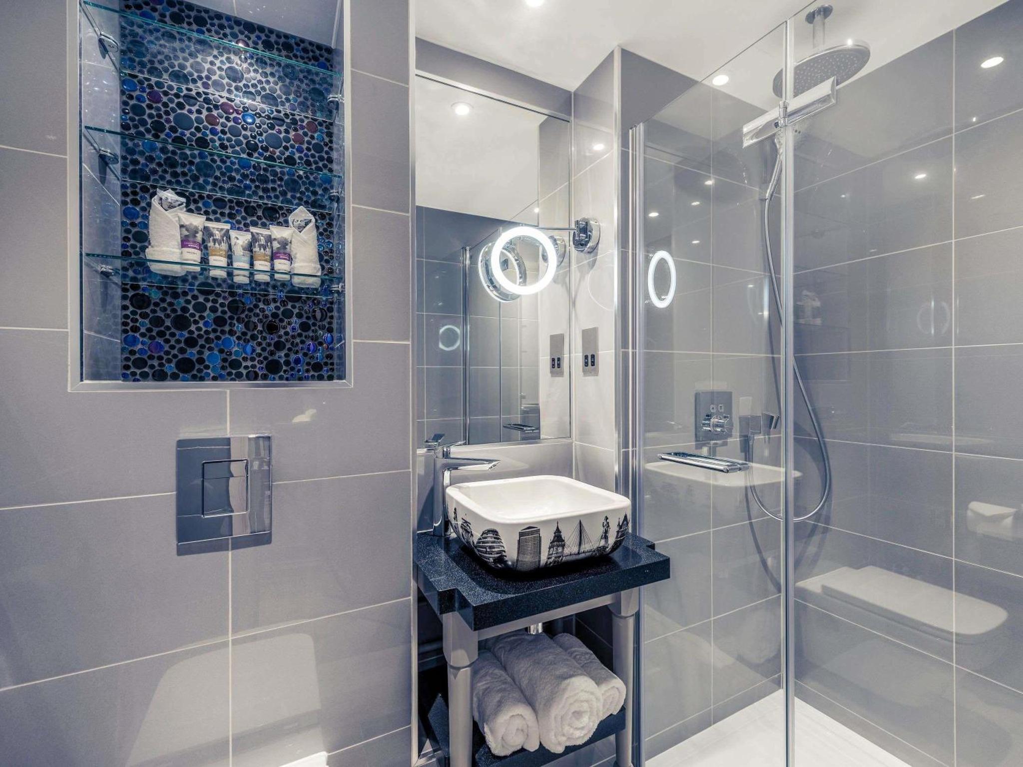 a bathroom with a glass shower and a sink at Mercure London Hyde Park Hotel in London