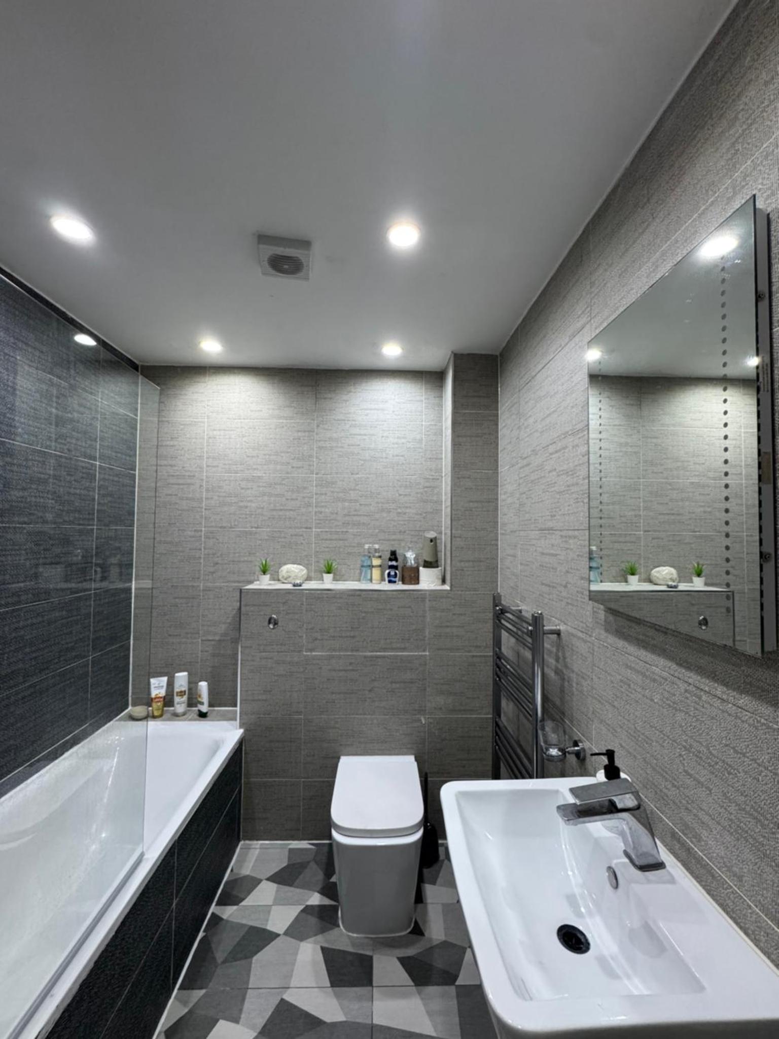a bathroom with a tub and a toilet and a sink at Modern Apartment Central London in London +16 photos