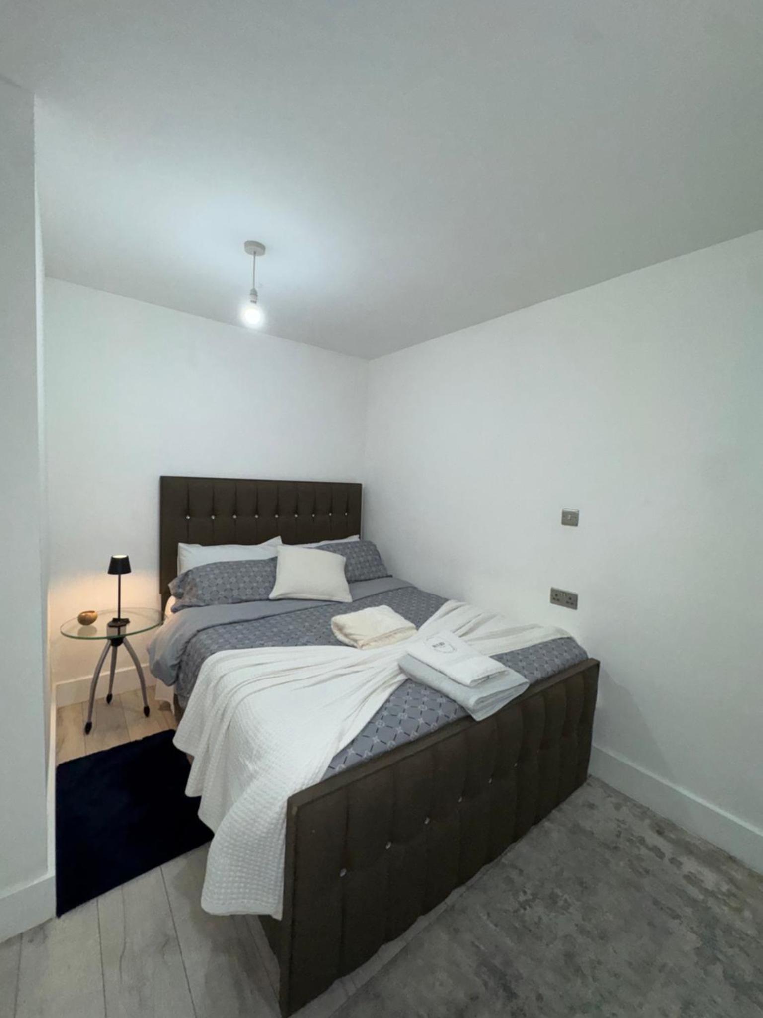 a bedroom with a large bed and a table at Modern Apartment Central London in London