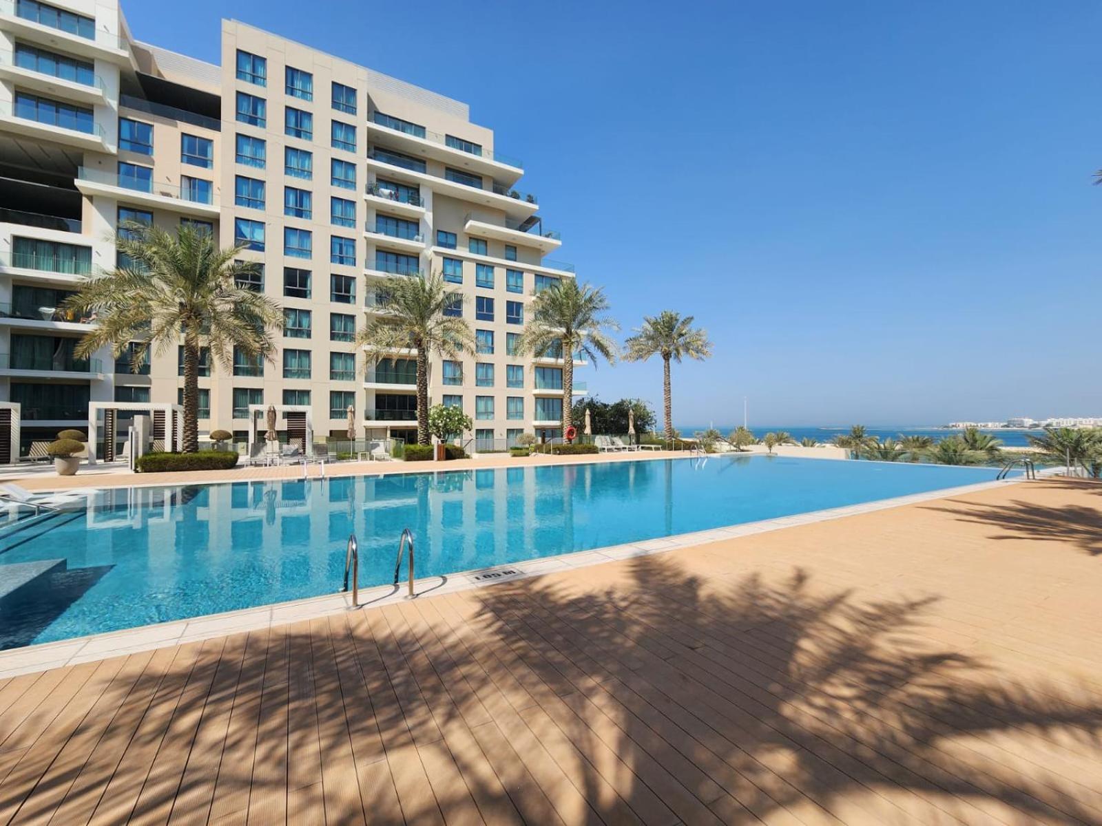 a large swimming pool in front of a building at Elite 2BR Abode Distinctive Living at The Shores in Manama