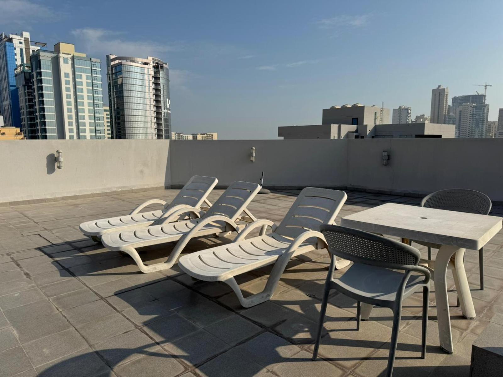 a row of chairs and a table on a roof at INFINITY Suites Juffair in Manama