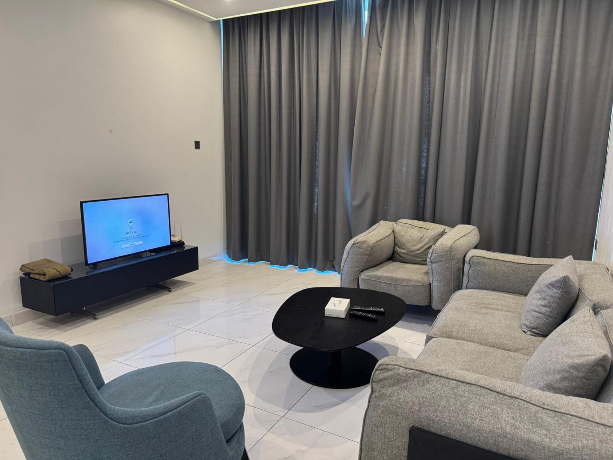 a living room with two couches and a flat screen tv at INFINITY Suites Juffair in Manama