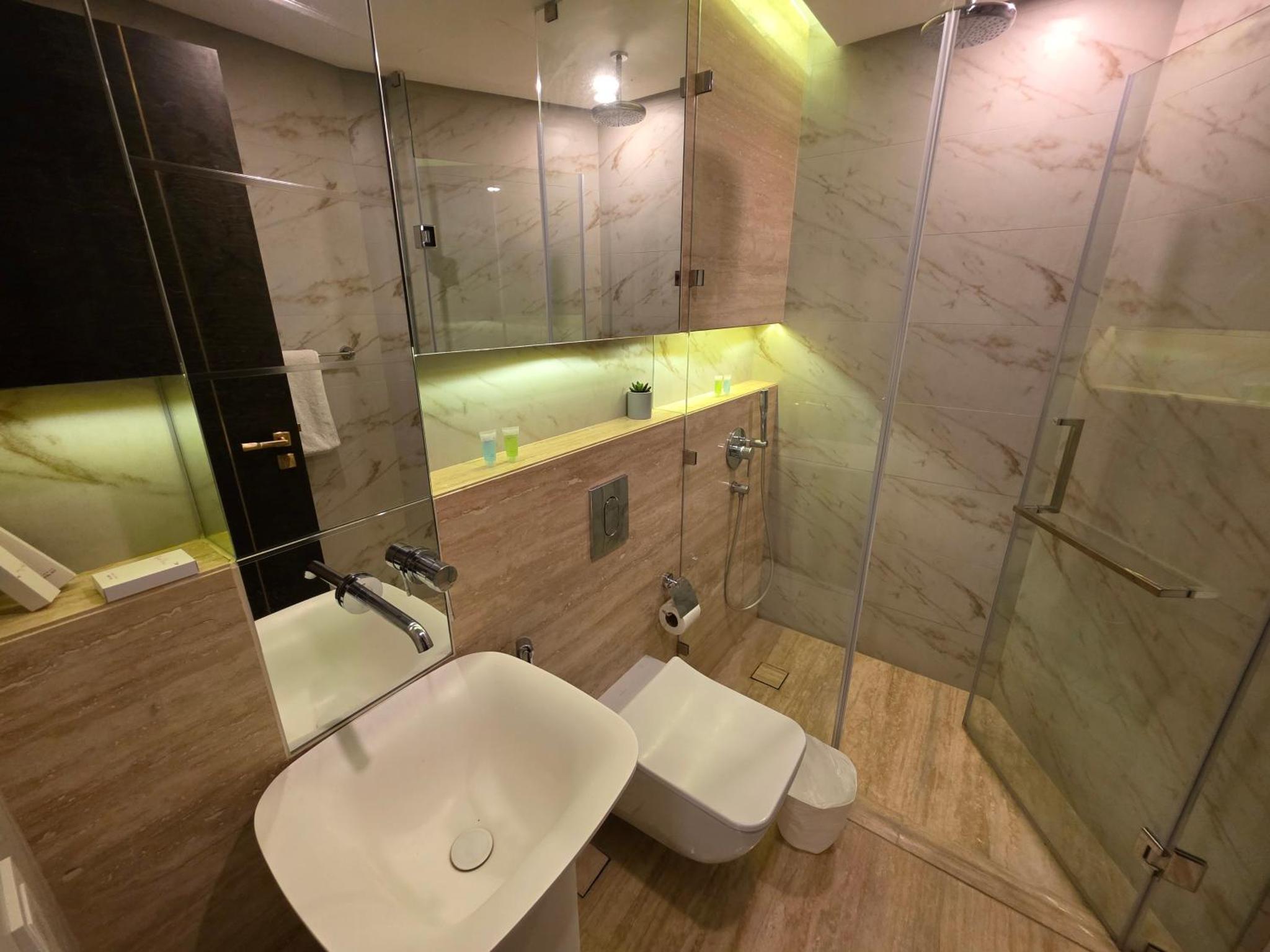 a bathroom with a toilet and a sink and a shower at Elite 1BR - Sea View & Four Seasons Scene in Manama