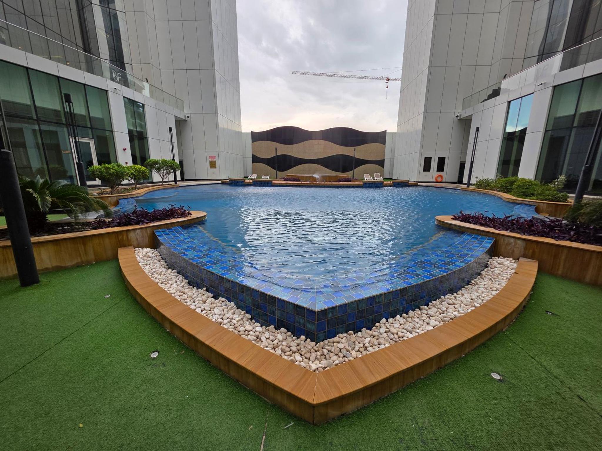 a large swimming pool in the middle of a building at Elite 1BR - Sea View & Four Seasons Scene in Manama