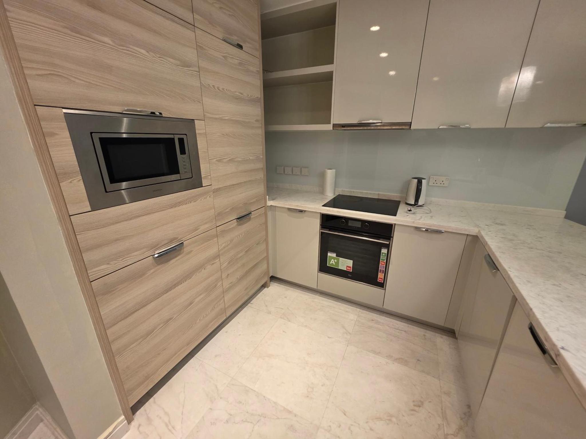 a kitchen with a microwave and a counter top at Elite 1BR - Sea View & Four Seasons Scene in Manama