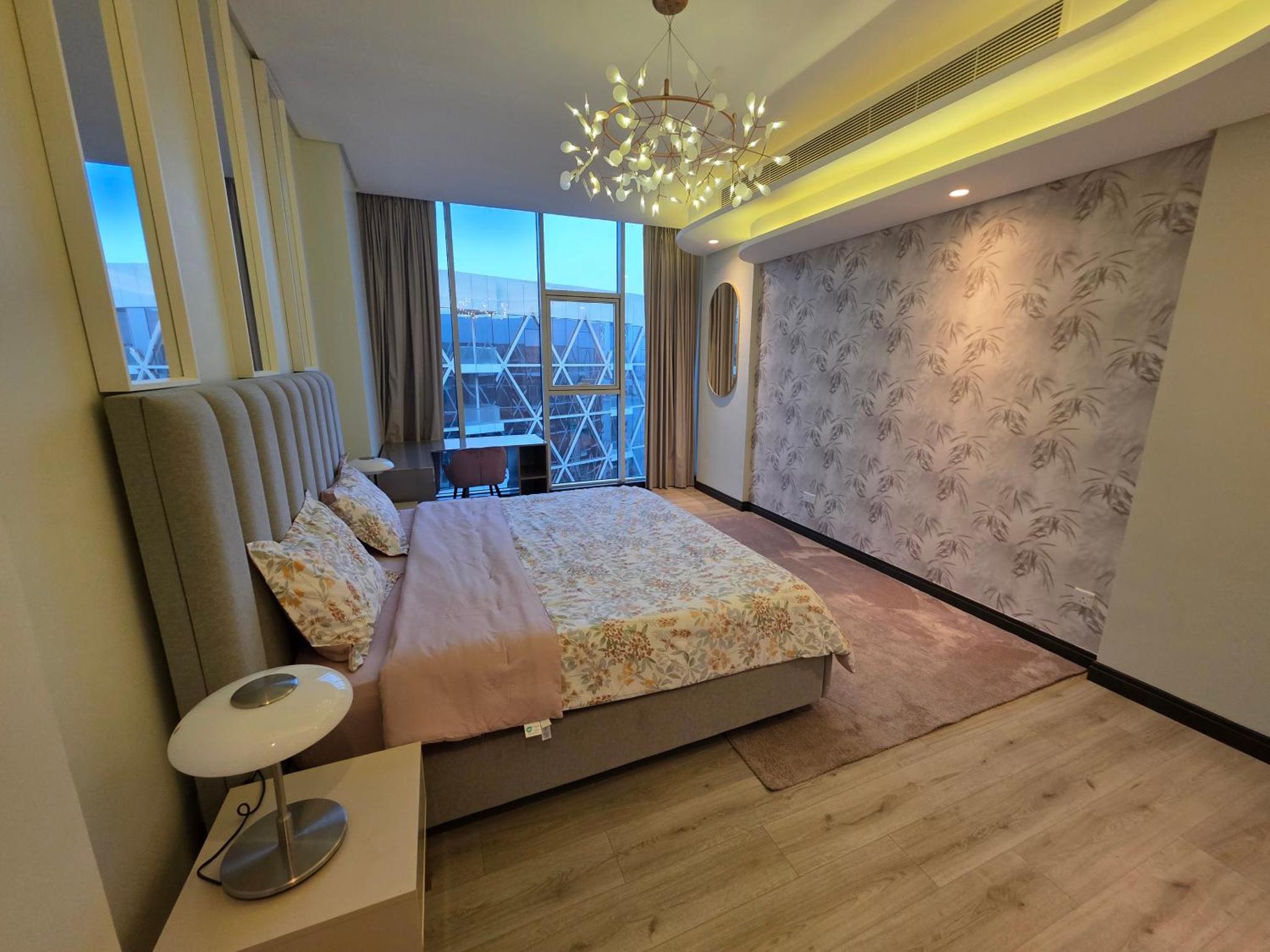 a bedroom with a bed and a large window at Elite 1BR - Sea View & Four Seasons Scene in Manama +25 photos