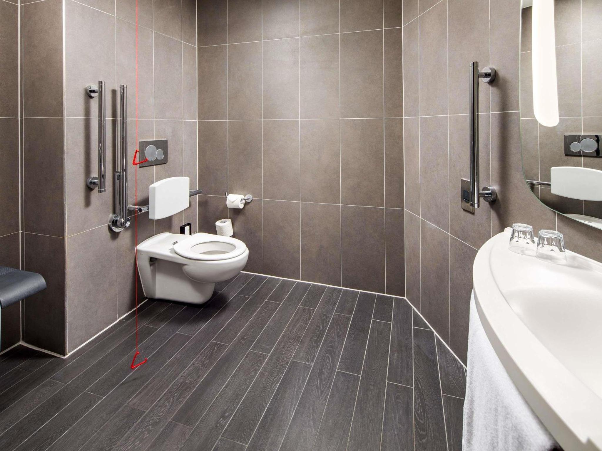 a bathroom with a toilet and a sink at ibis London Canning Town in London +89 photos