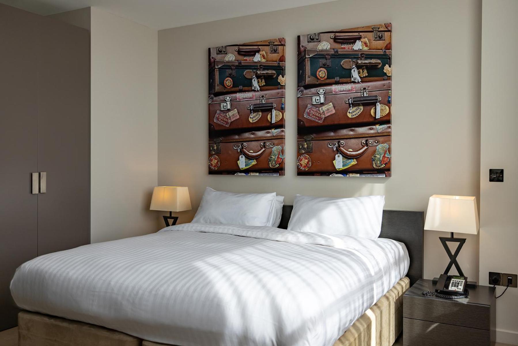 a bedroom with a bed and two paintings on the wall at Hotel Xanadu in London