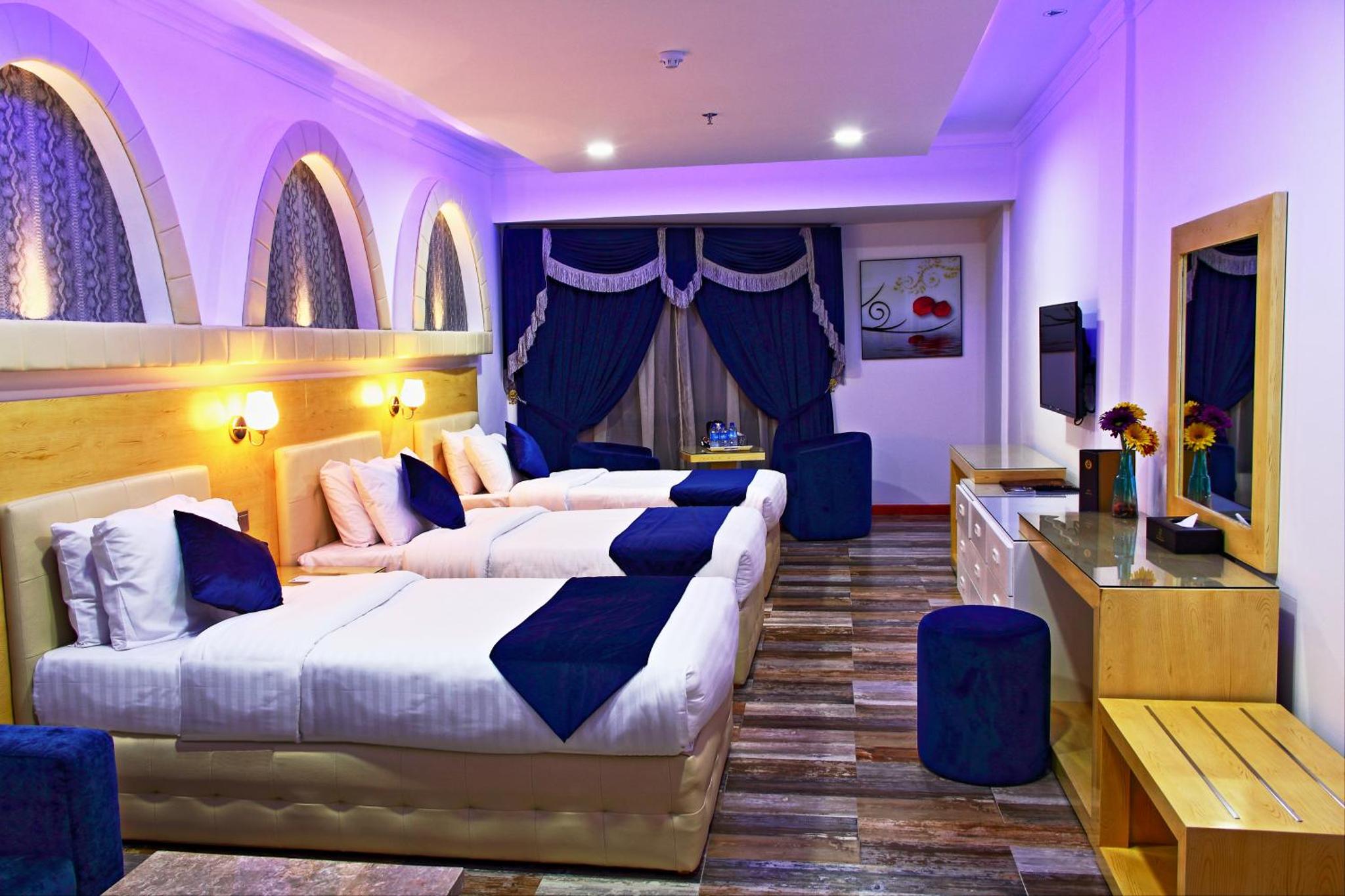 a hotel room with two beds and a television at Bahrain International Hotel in Manama