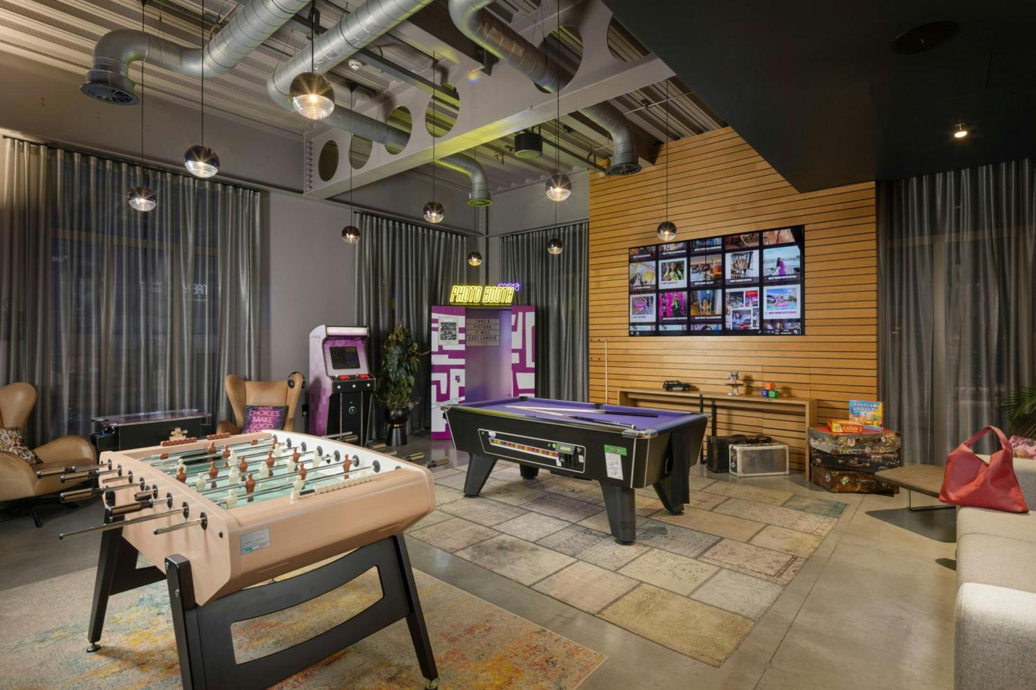 a living room with a pool table and a game at Moxy London Excel in London