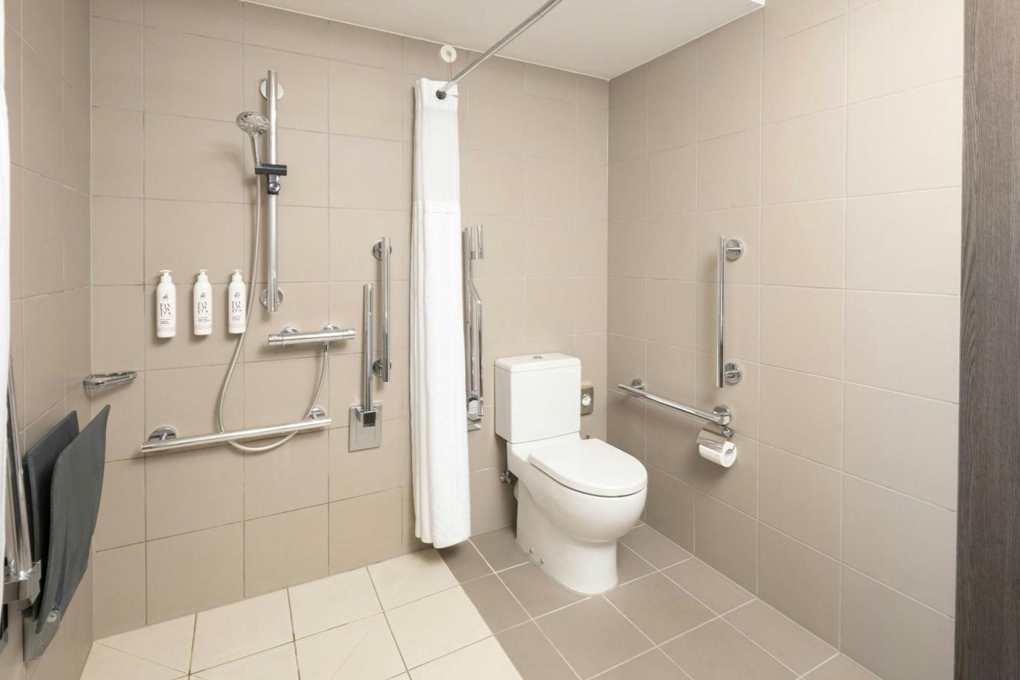 a bathroom with a toilet and a shower stall at Moxy London Excel in London +78 photos