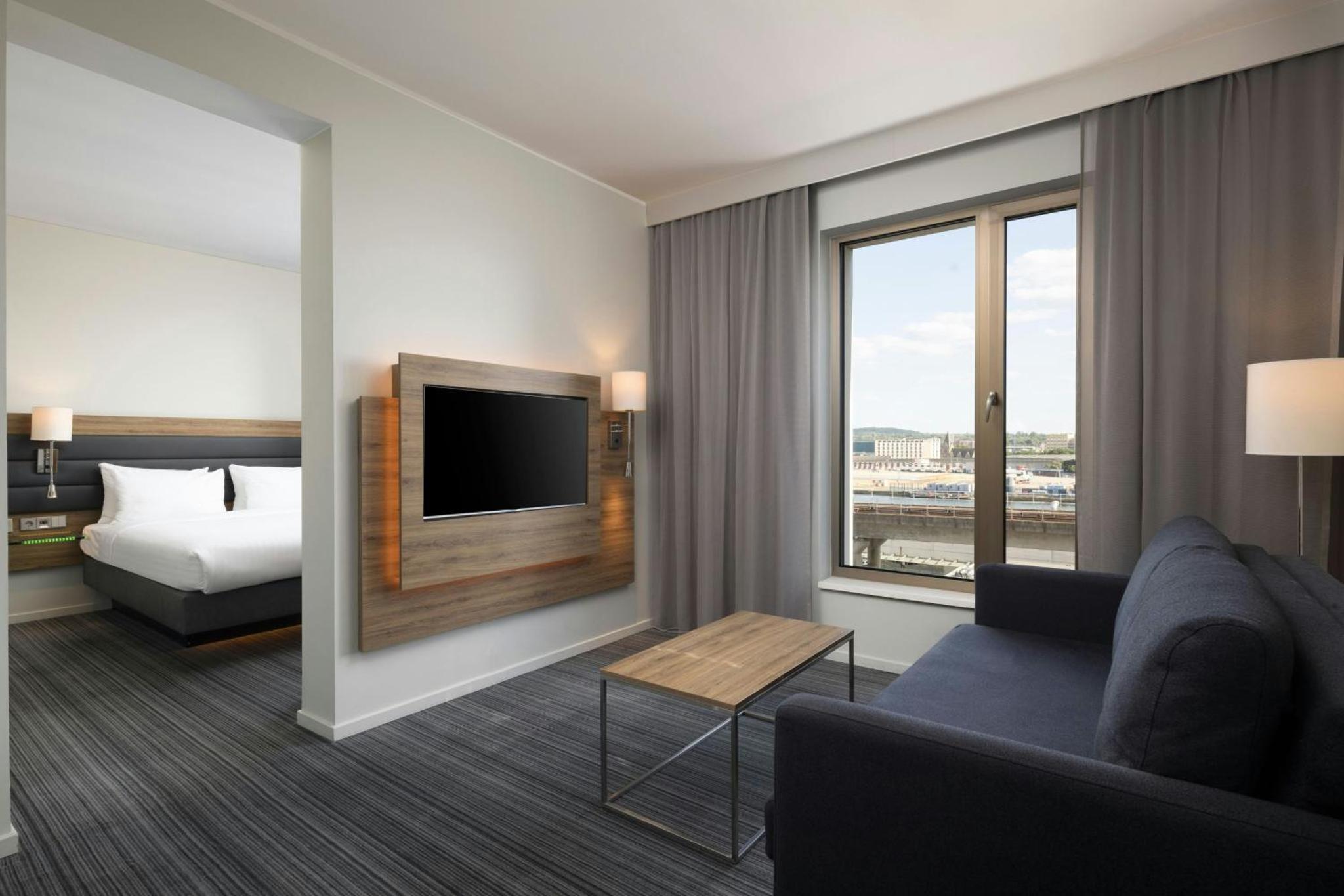 a hotel room with a couch and a bed at Moxy London Excel in London