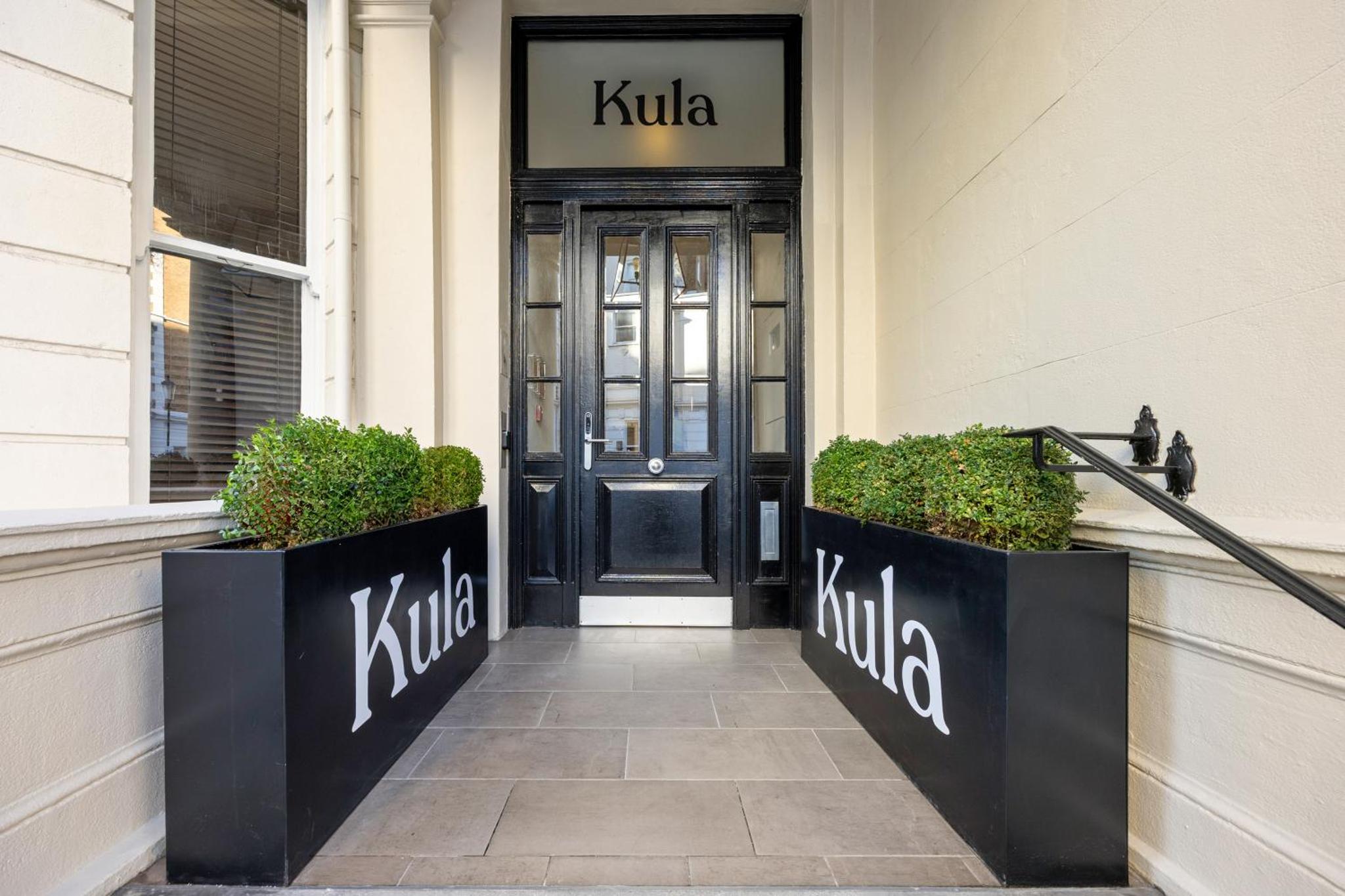 a kilt entrance to a building with a black door at Stay Kula London - Kensington in London