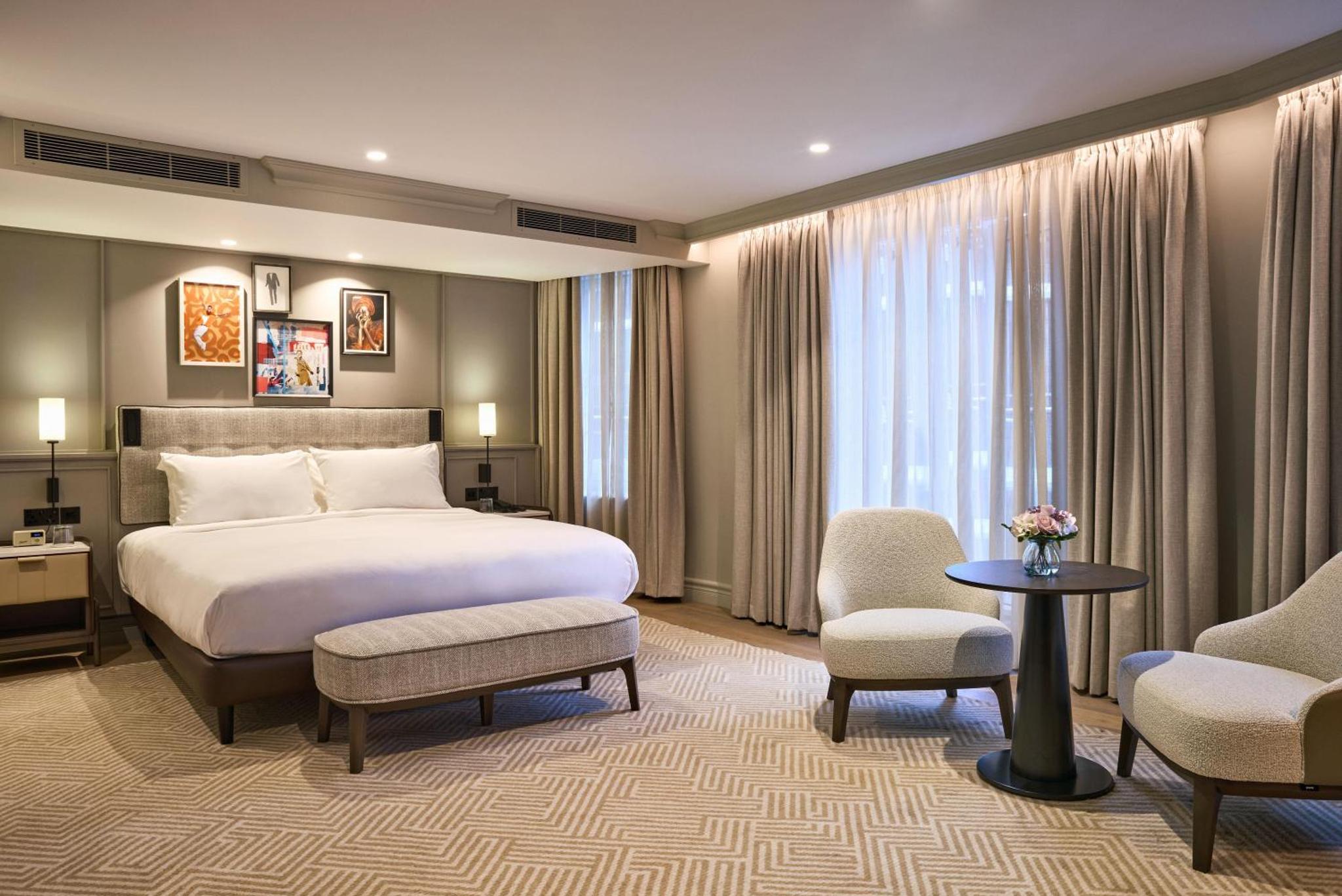 a hotel room with a bed and two chairs at Radisson Blu Hotel, London Bond Street in London