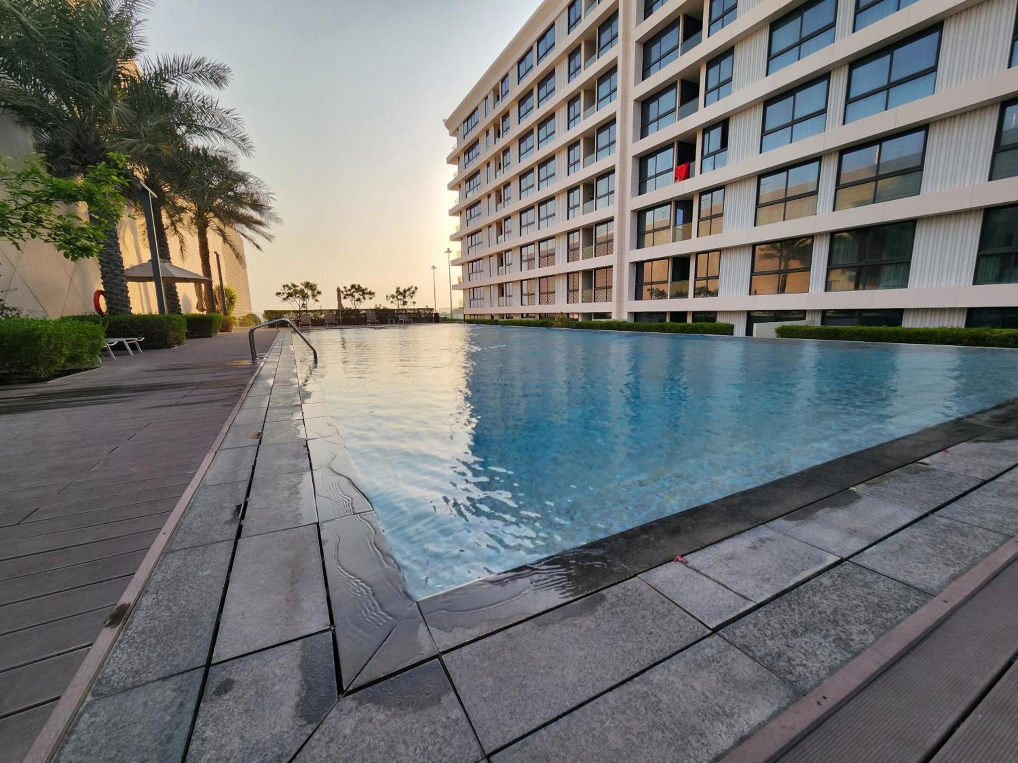 a large swimming pool in front of a building at Luxury 2BR with Private Garden Marassi Living in Rayyā