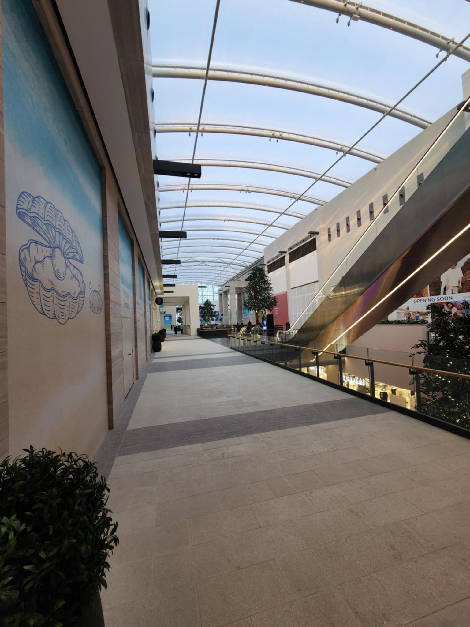 an empty hallway in a building with a ceiling at Luxury 2BR with Private Garden Marassi Living in Rayyā